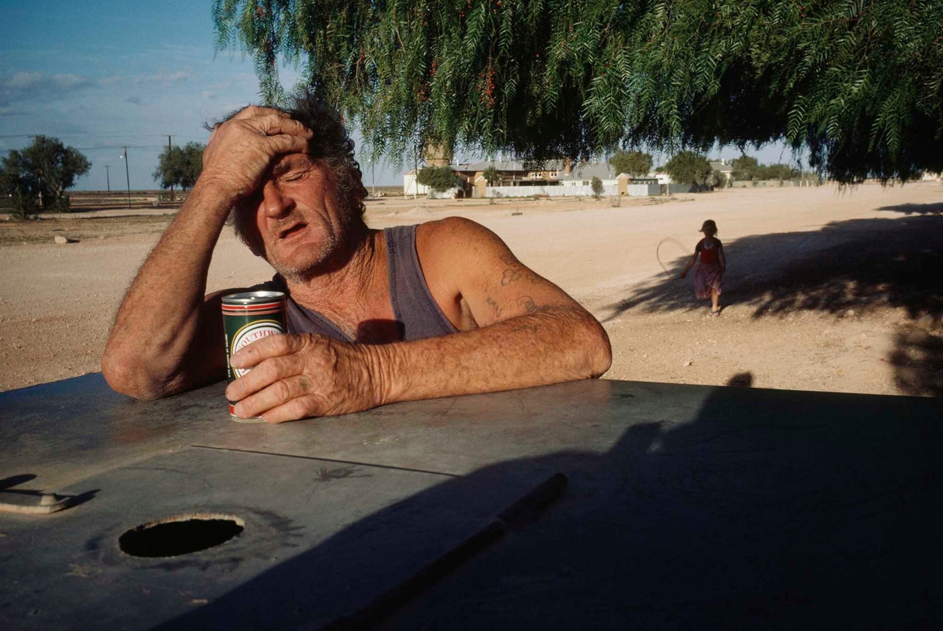 a railroad worker breaking from the heat with a beer