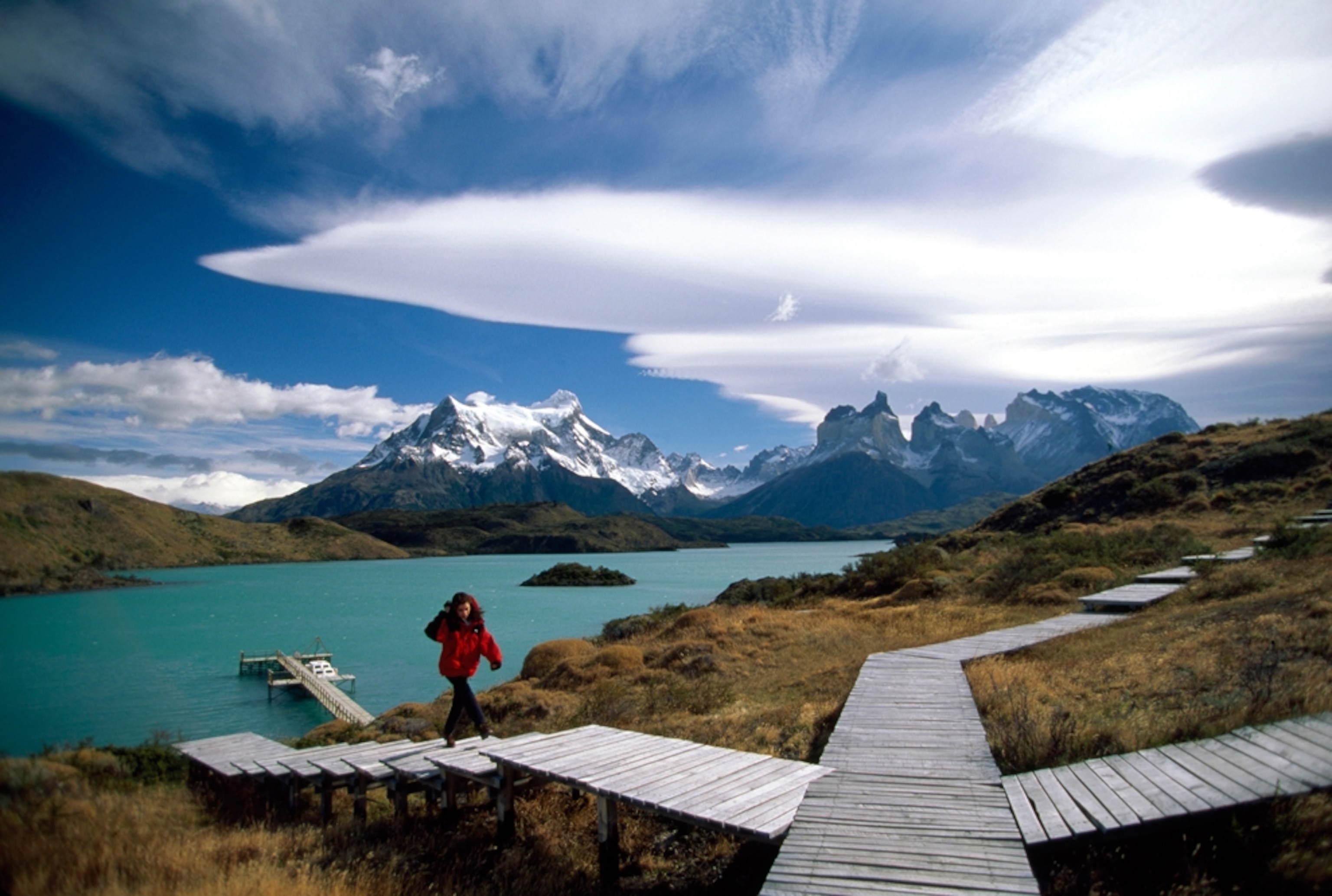 a woman walking through Torres del Paine park in Patagonia, Chile