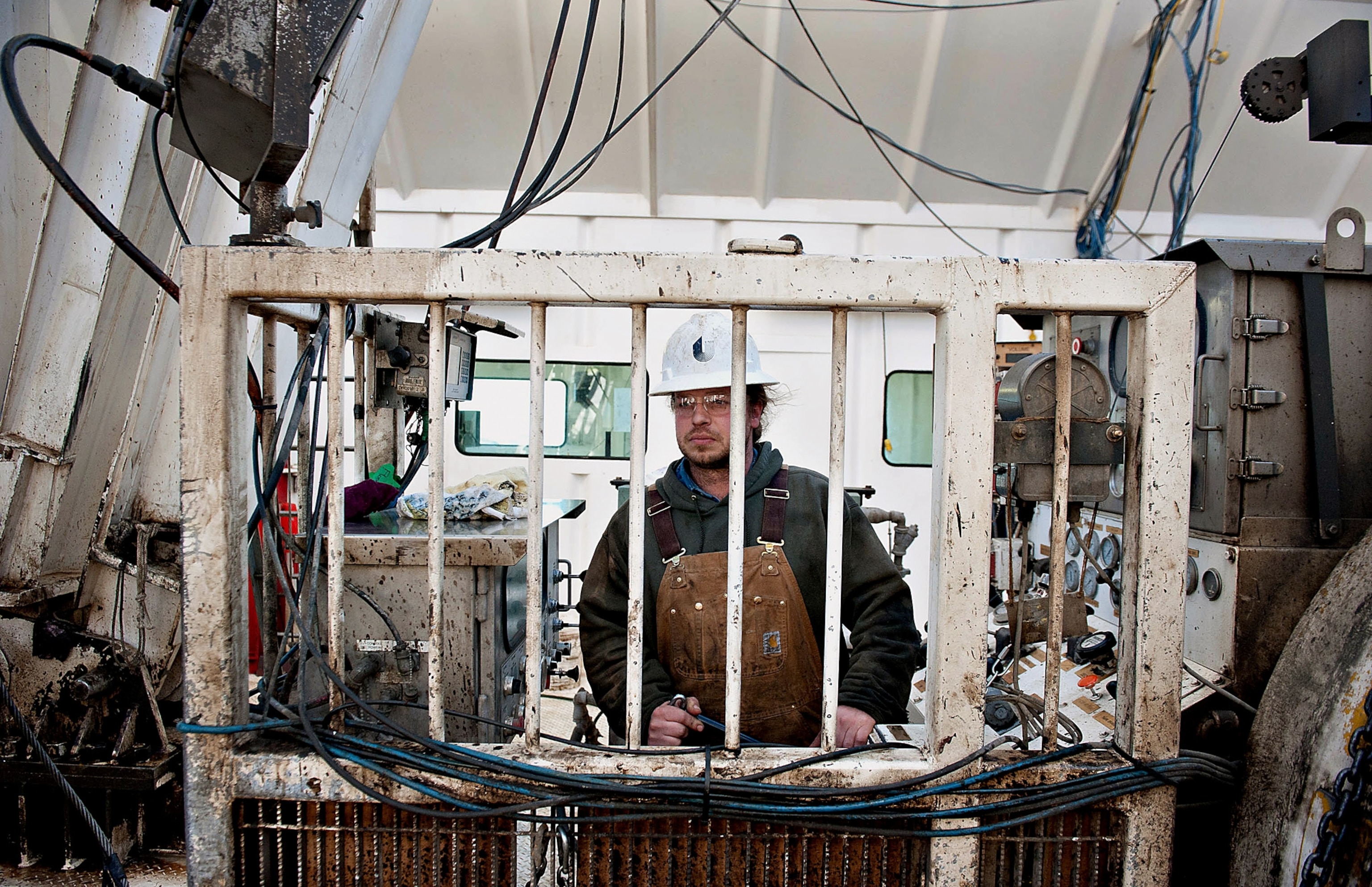 a worker at the controls of a drilling rig in Watford City, North Dakota
