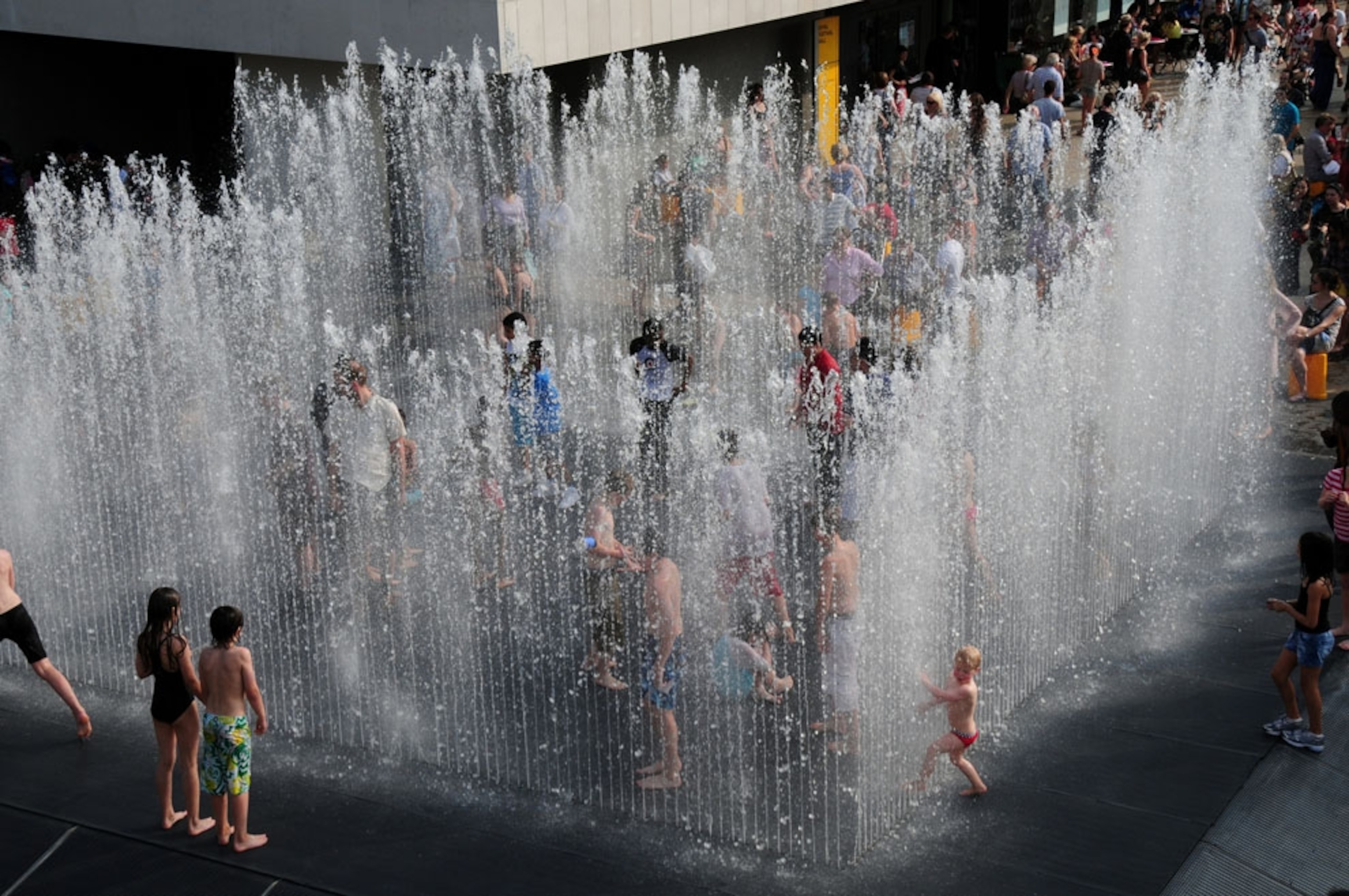 Children play in a fountain in South Bank, London