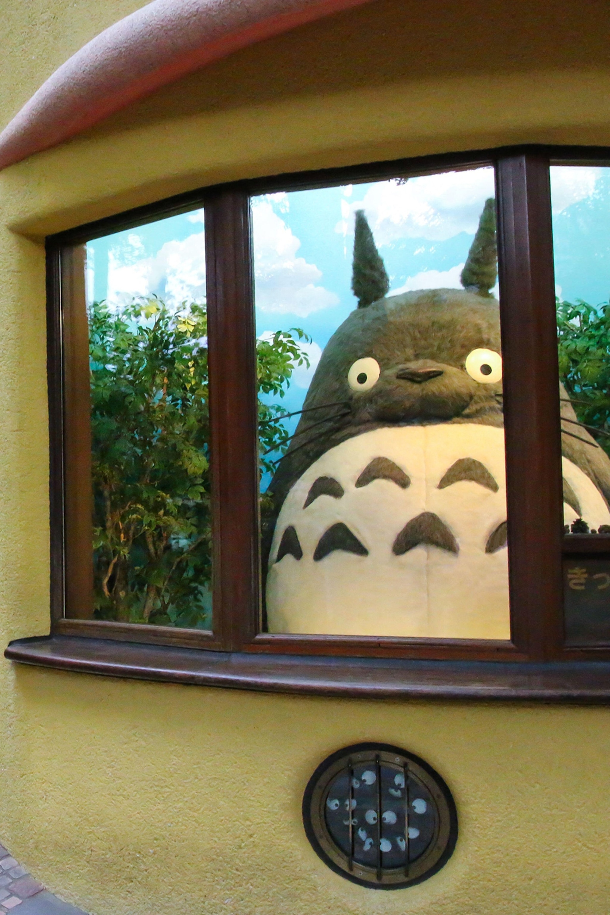 A life-sized statue of a cartoon character behind a glass window.