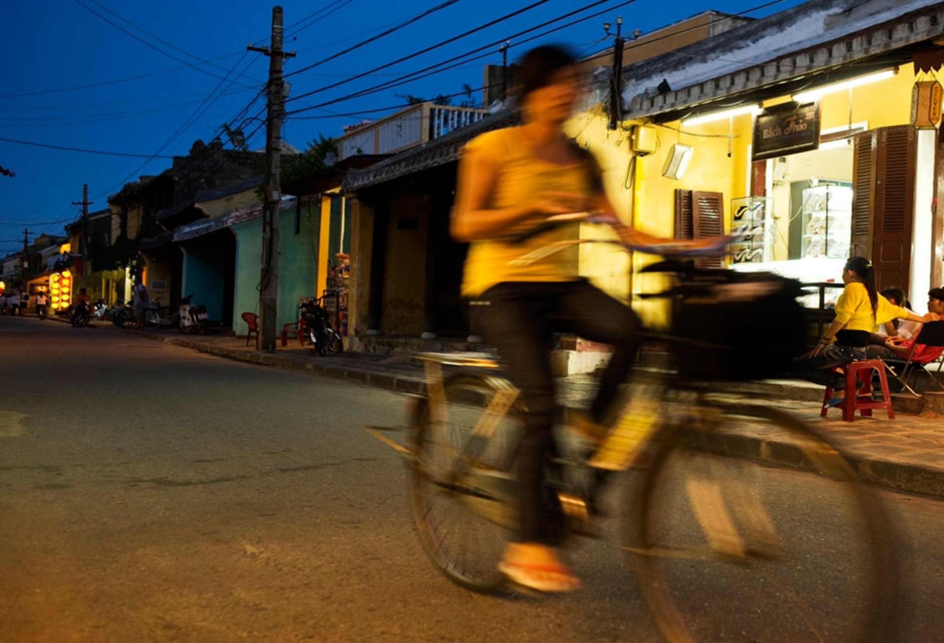 A woman riding a bike at night in Hoi An, Vietnam