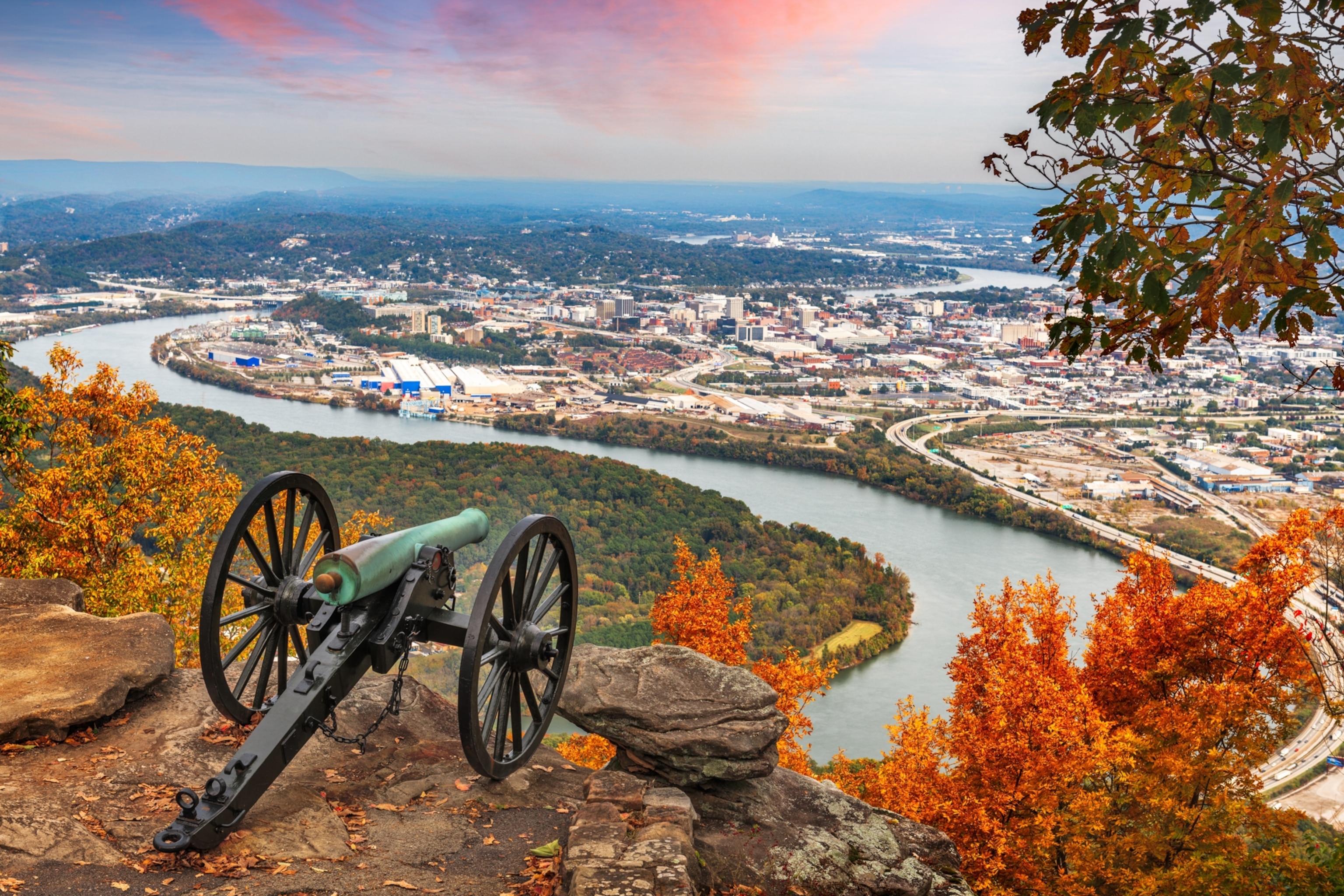 An old cannon on a hill overlooking a city