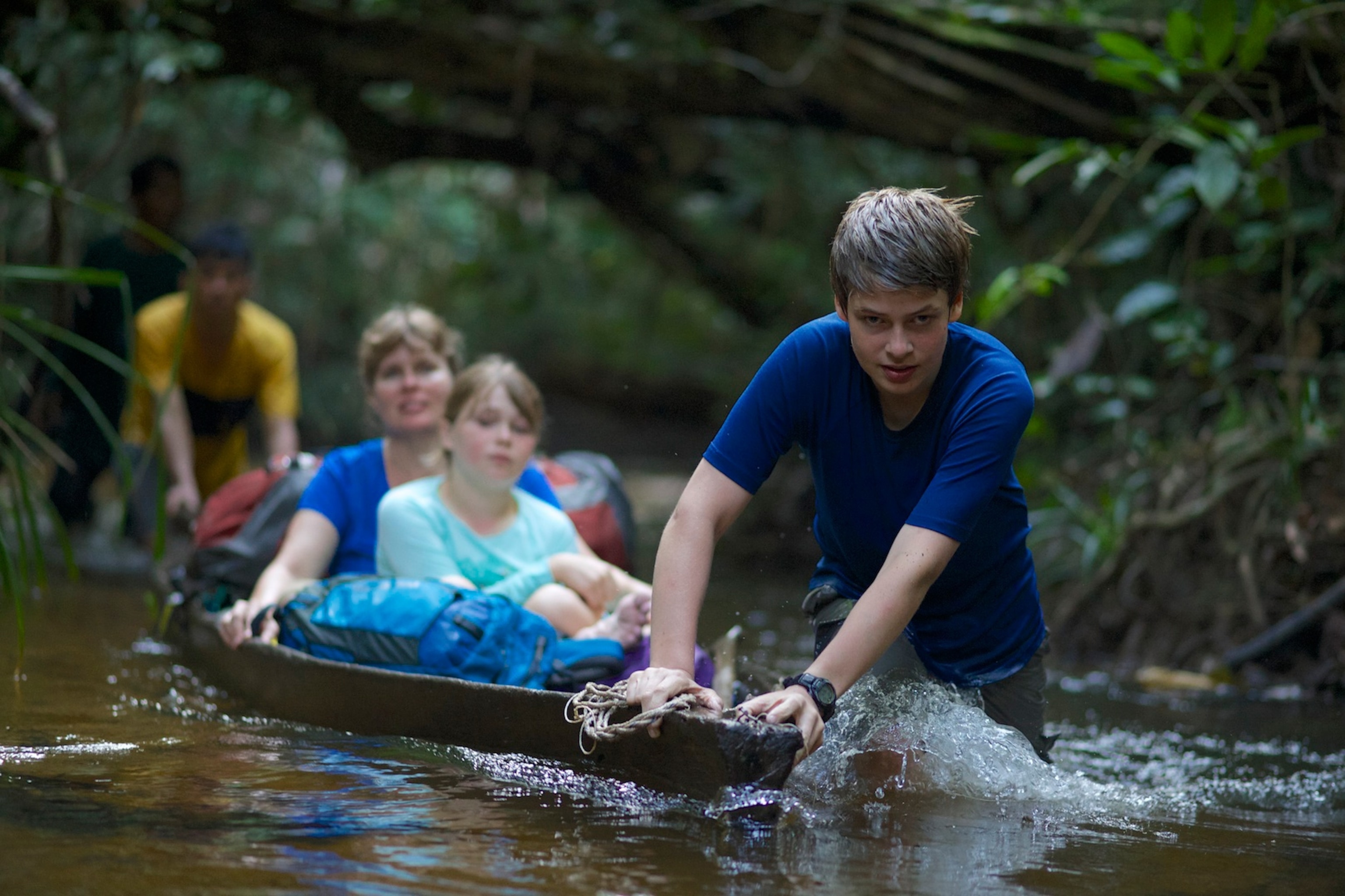 The Laman family traveling up the Air Putih river to reach the Cabang Panti Research Station. Gunung Palung National Park, West Kalimantan Province, Island of Borneo, Indonesia