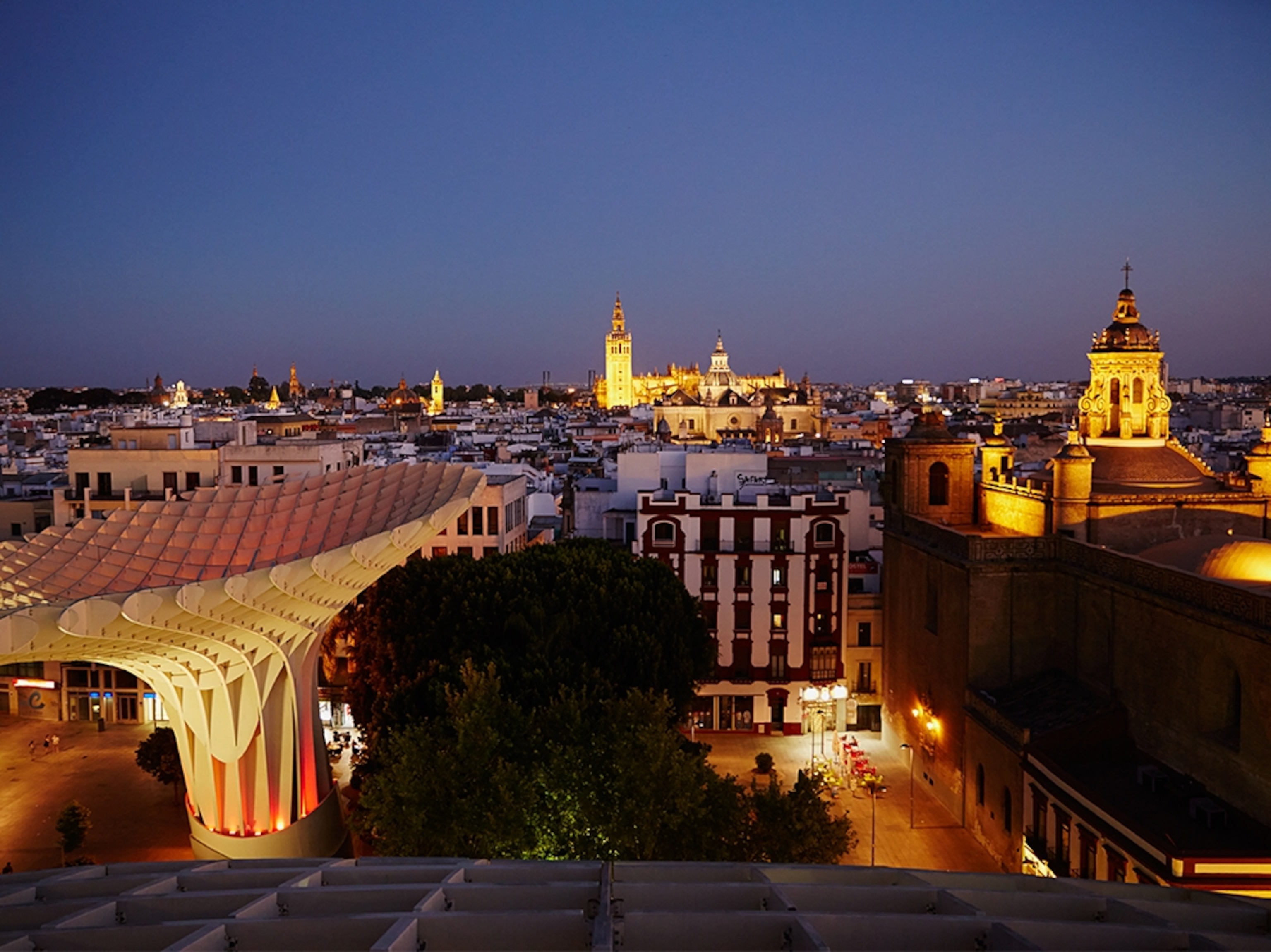 the Metropol Parasol and the city of Seville, Spain, at night