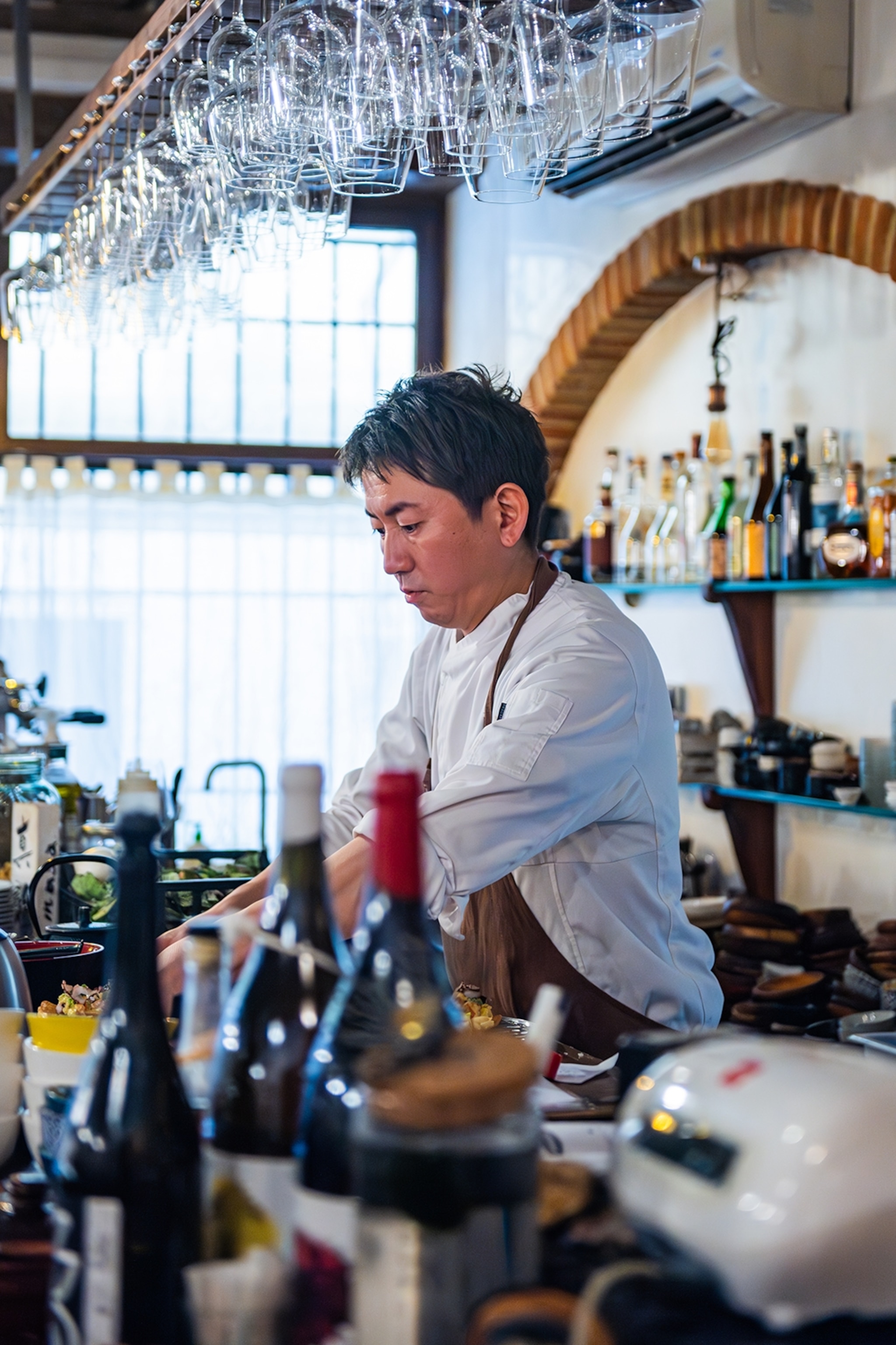 A Japanese chef working behind an open bar.