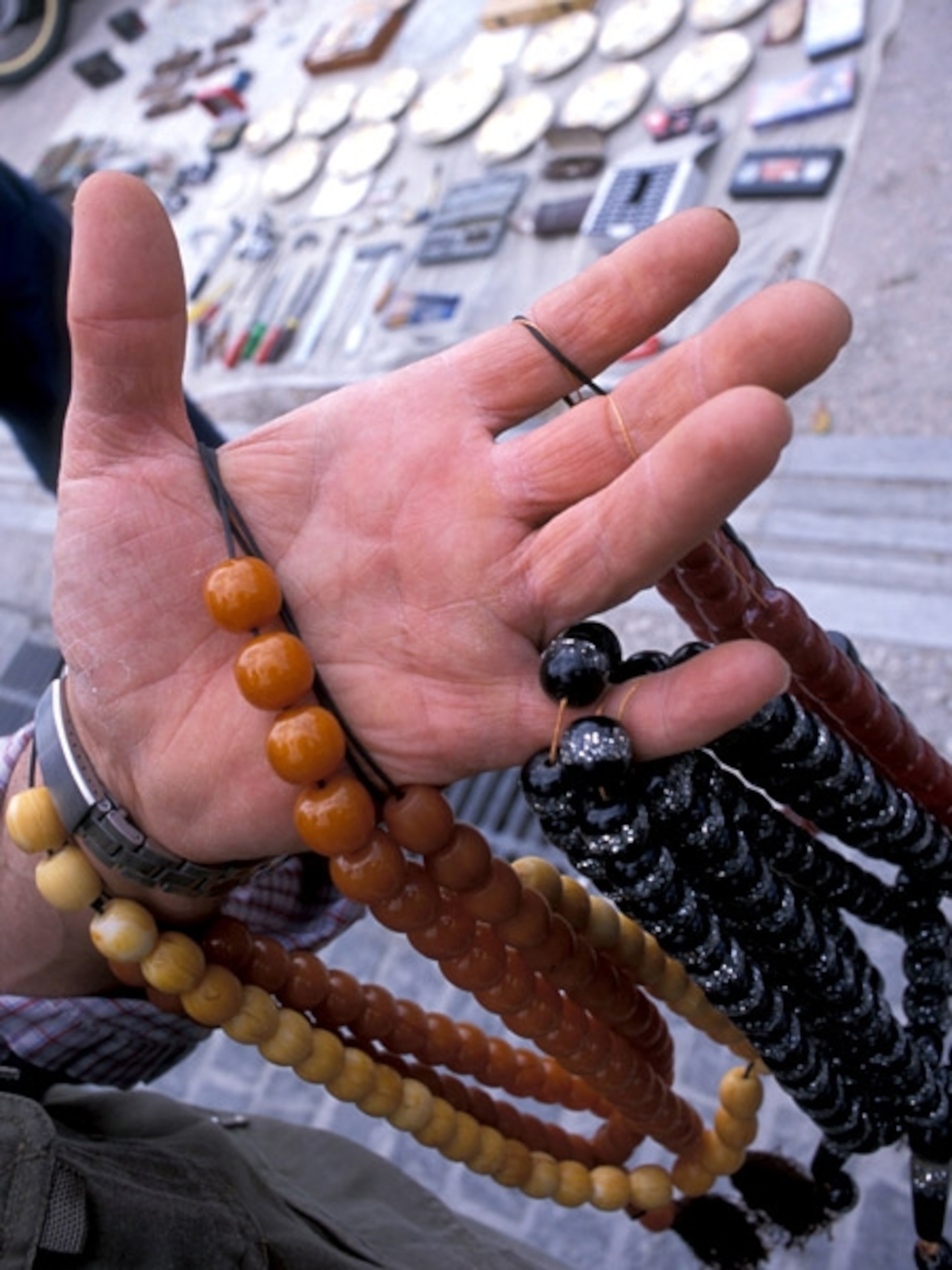 A shopper examining beads in the market