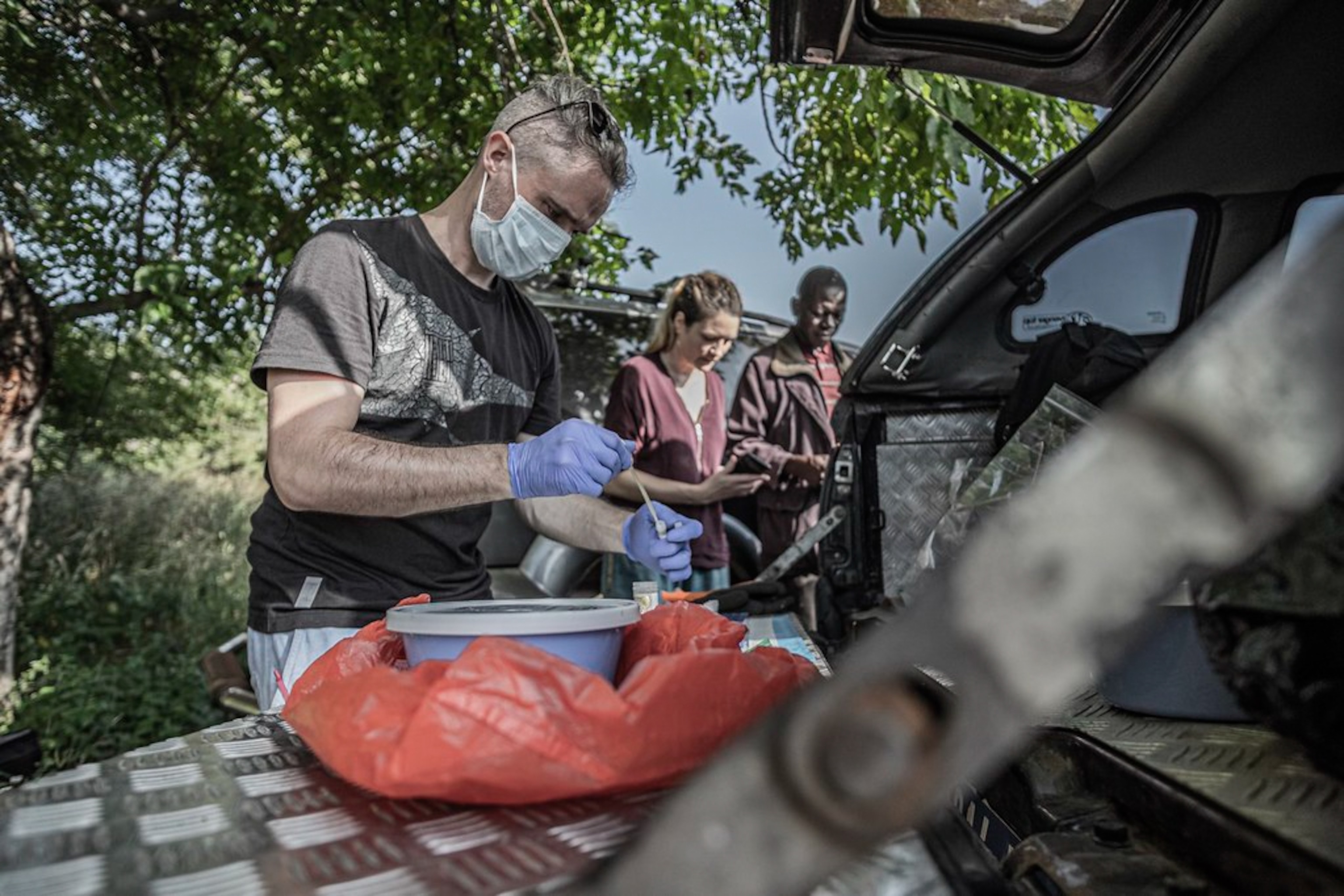 A man processes samples outdoors.