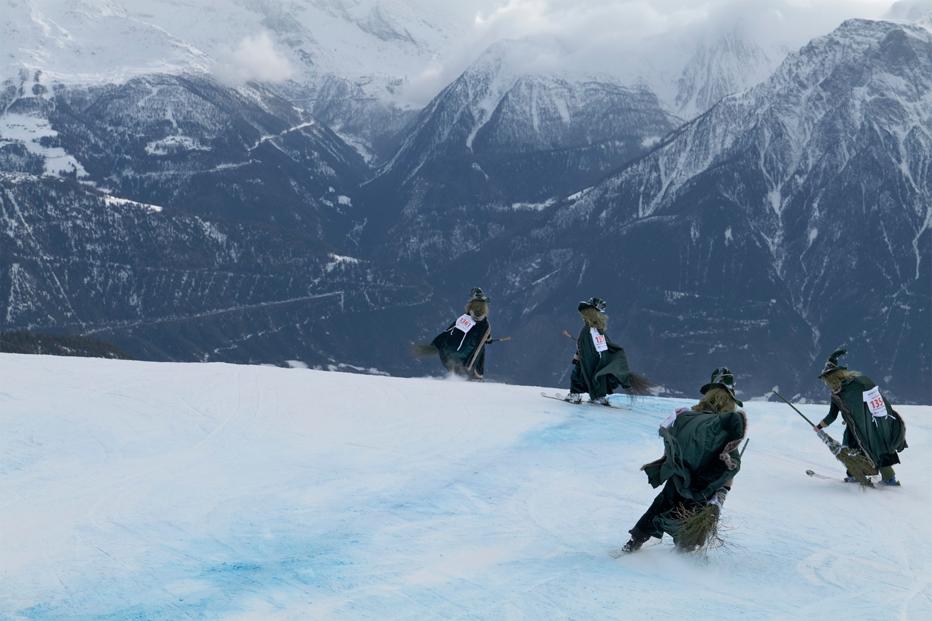 A team of skiers dressed as witches participate in the Belalp Hexen festival in Belalp, Switzerland. Participants ski down a race course wearing witch costumes.
