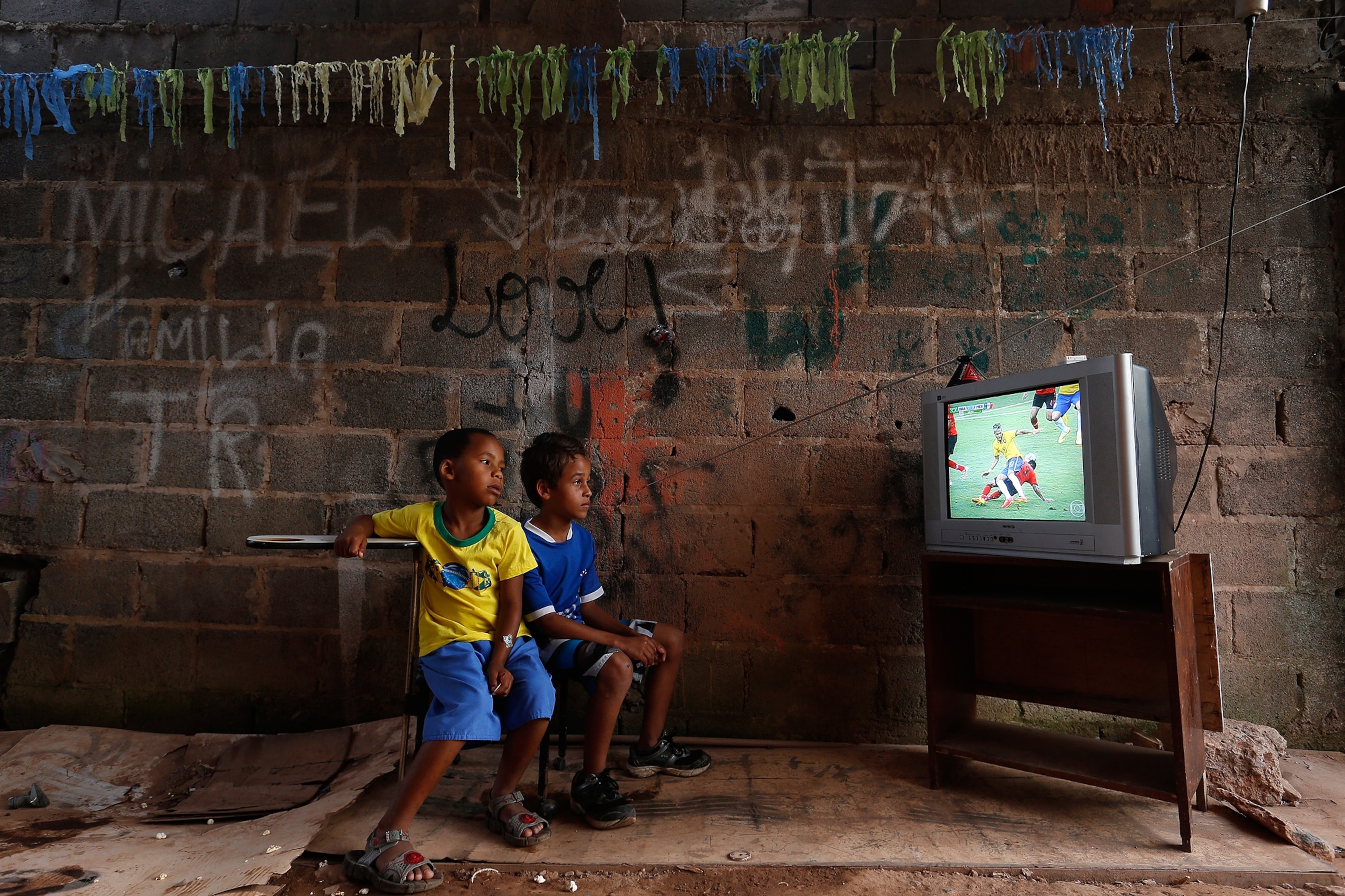 Boys watch a screening of the 2014 World Cup Group A soccer match between Brazil and Mexico, at the slum of Varjao on the outskirts of Brasilia.