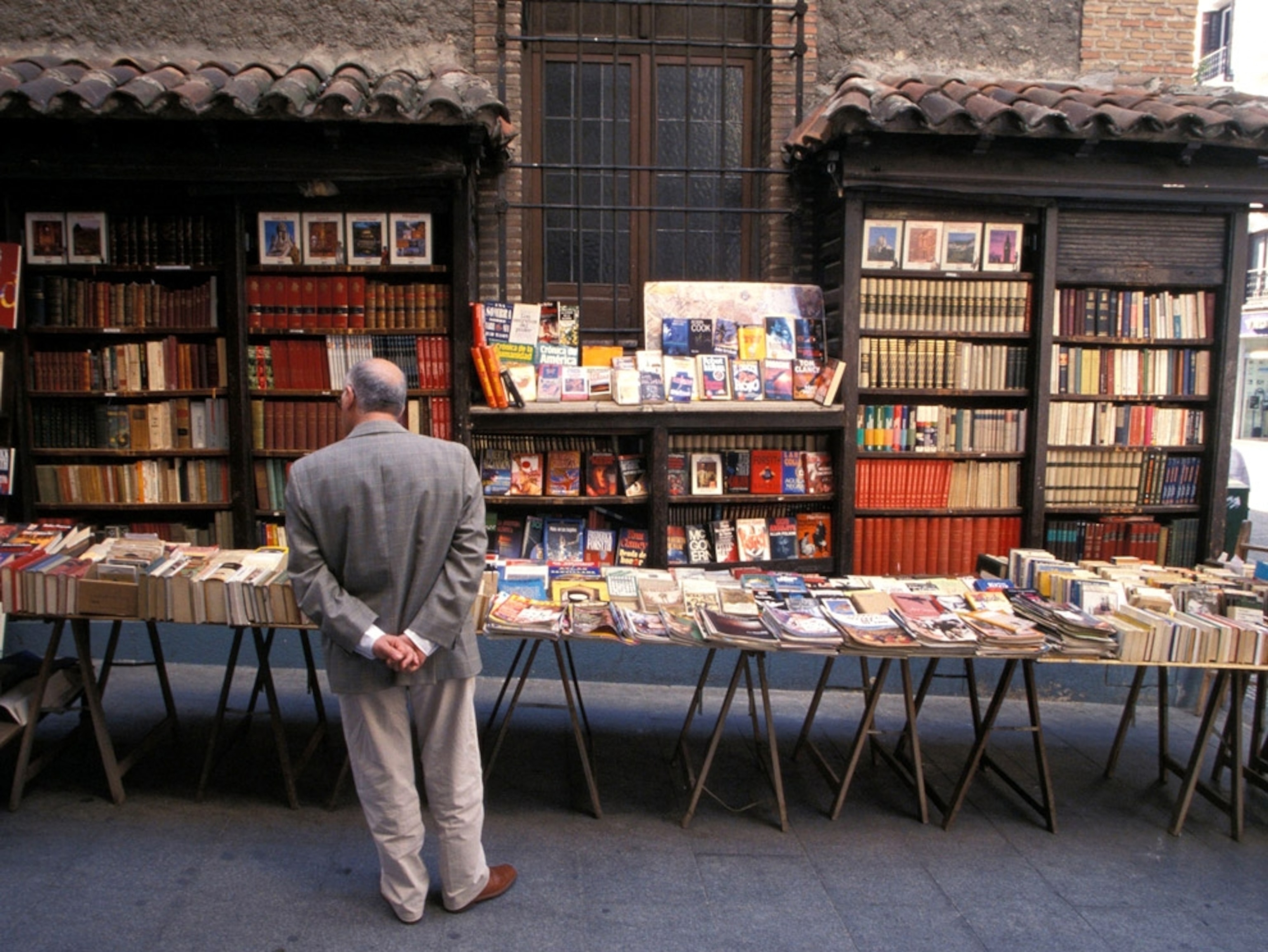 A man looking at a table of books for sale