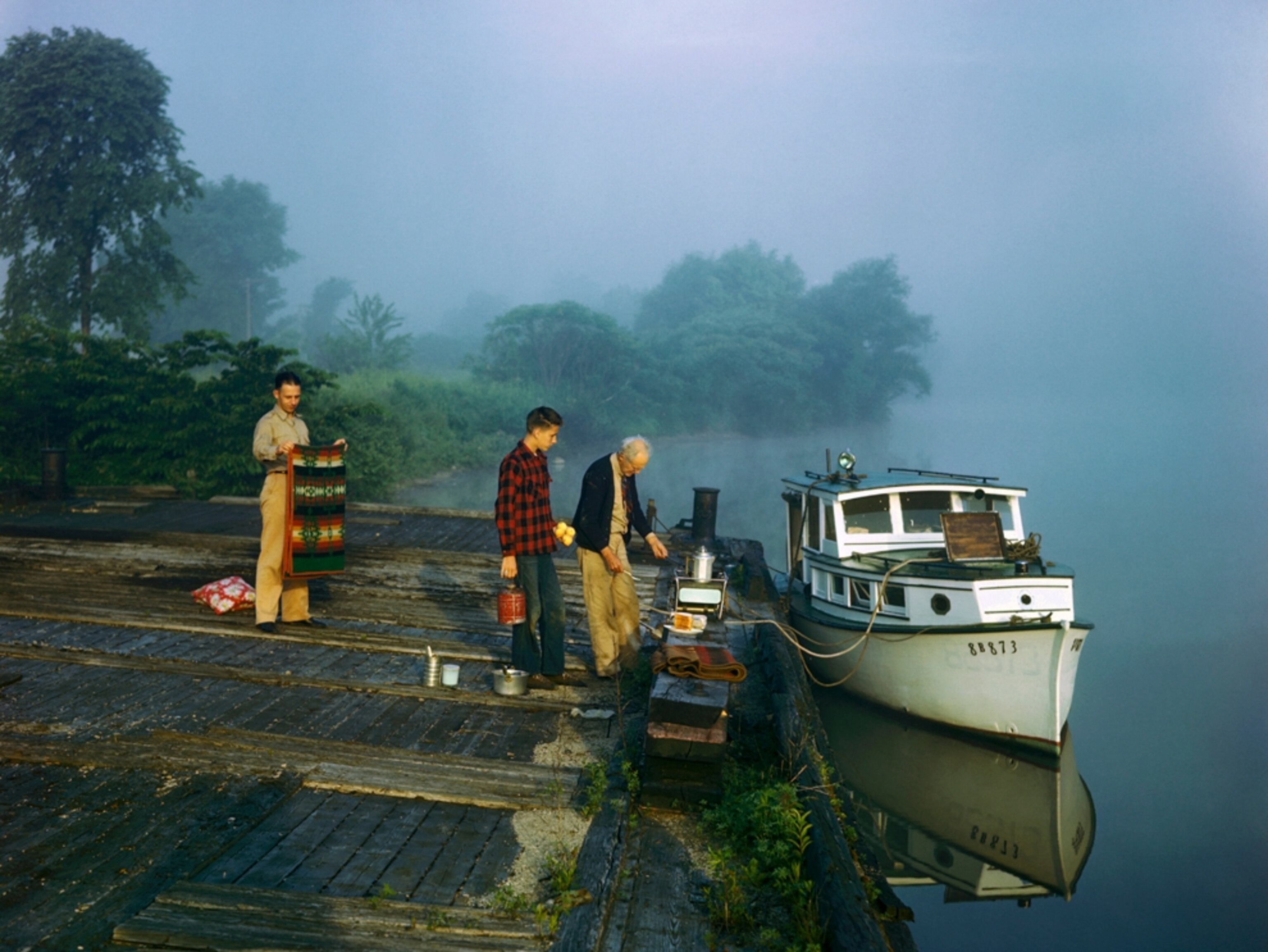 Men cooking breakfast by a river