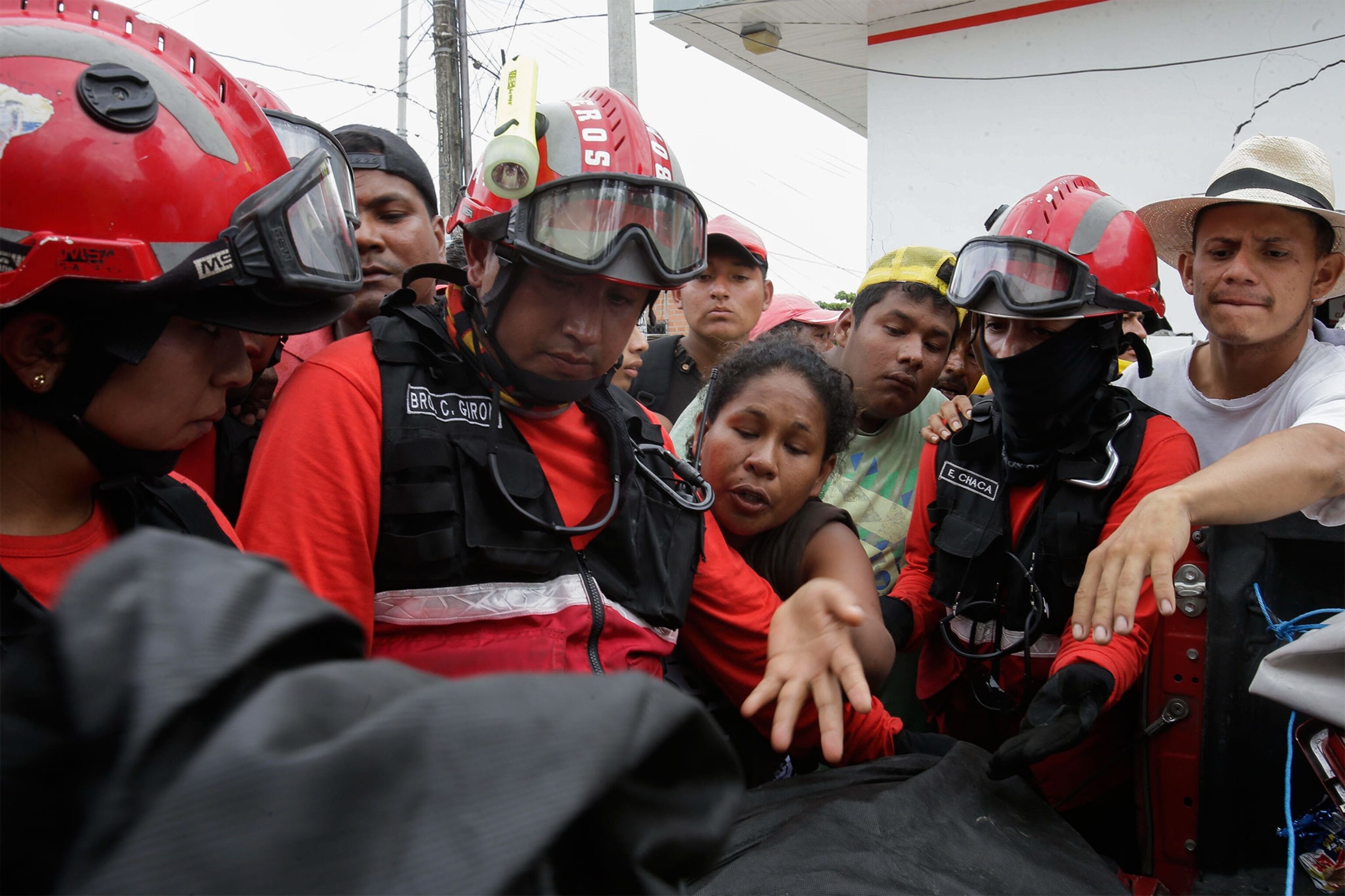 people talking to firefighters after an earthquake
