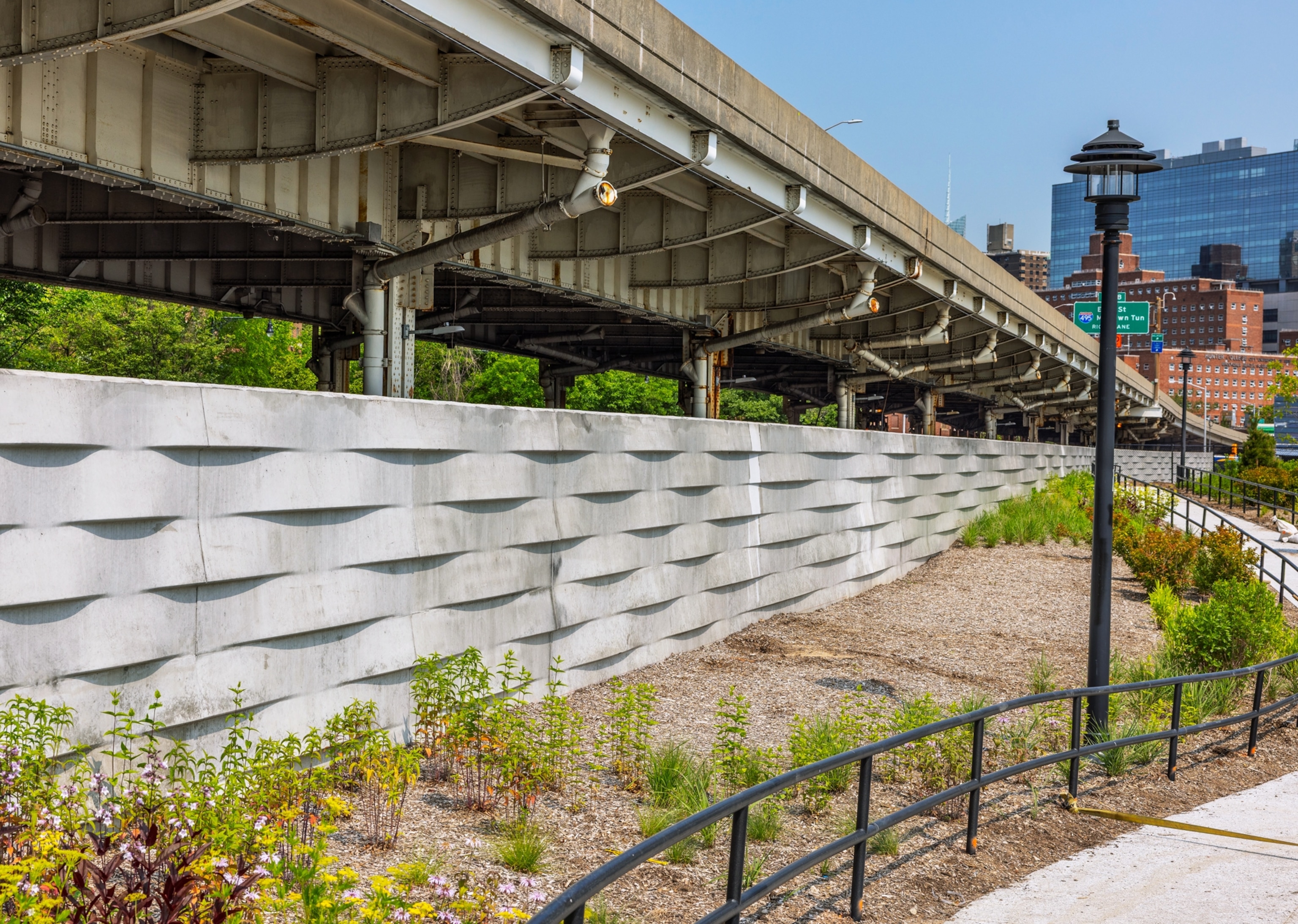 Basket design concrete wall hiding a house behind it.