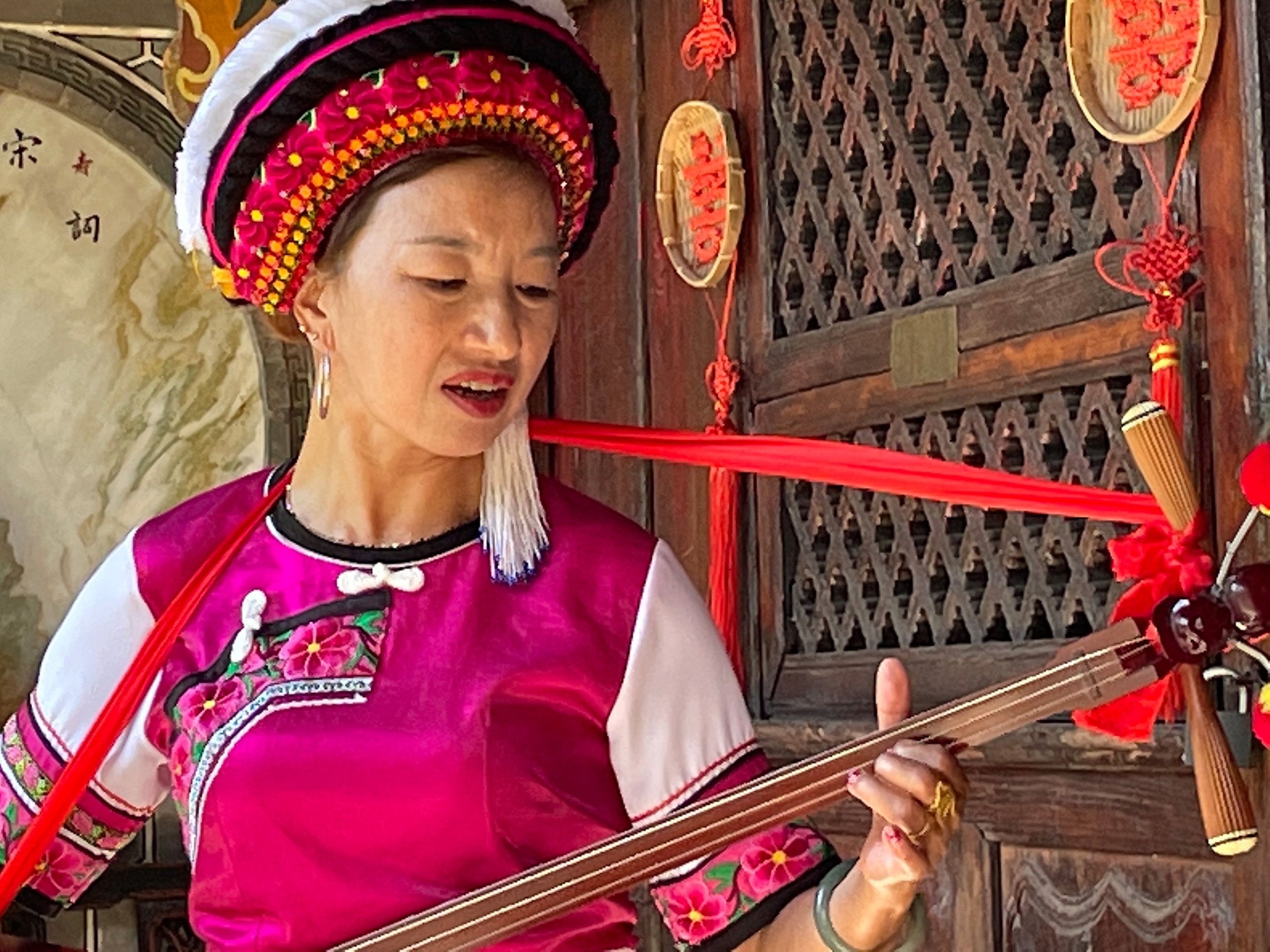 Photo of a woman dressed in pink playing a string instrument