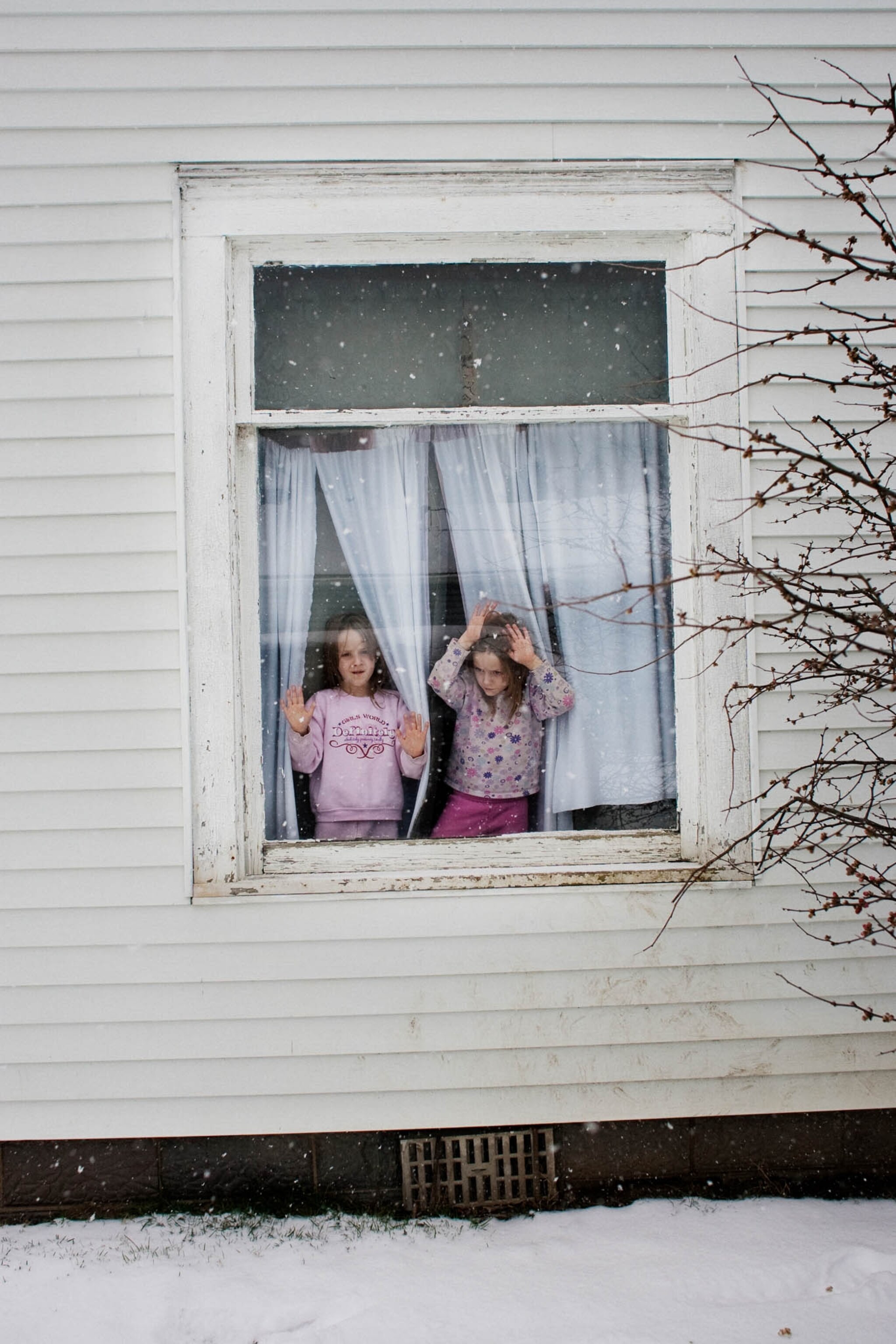 girls standing in a window