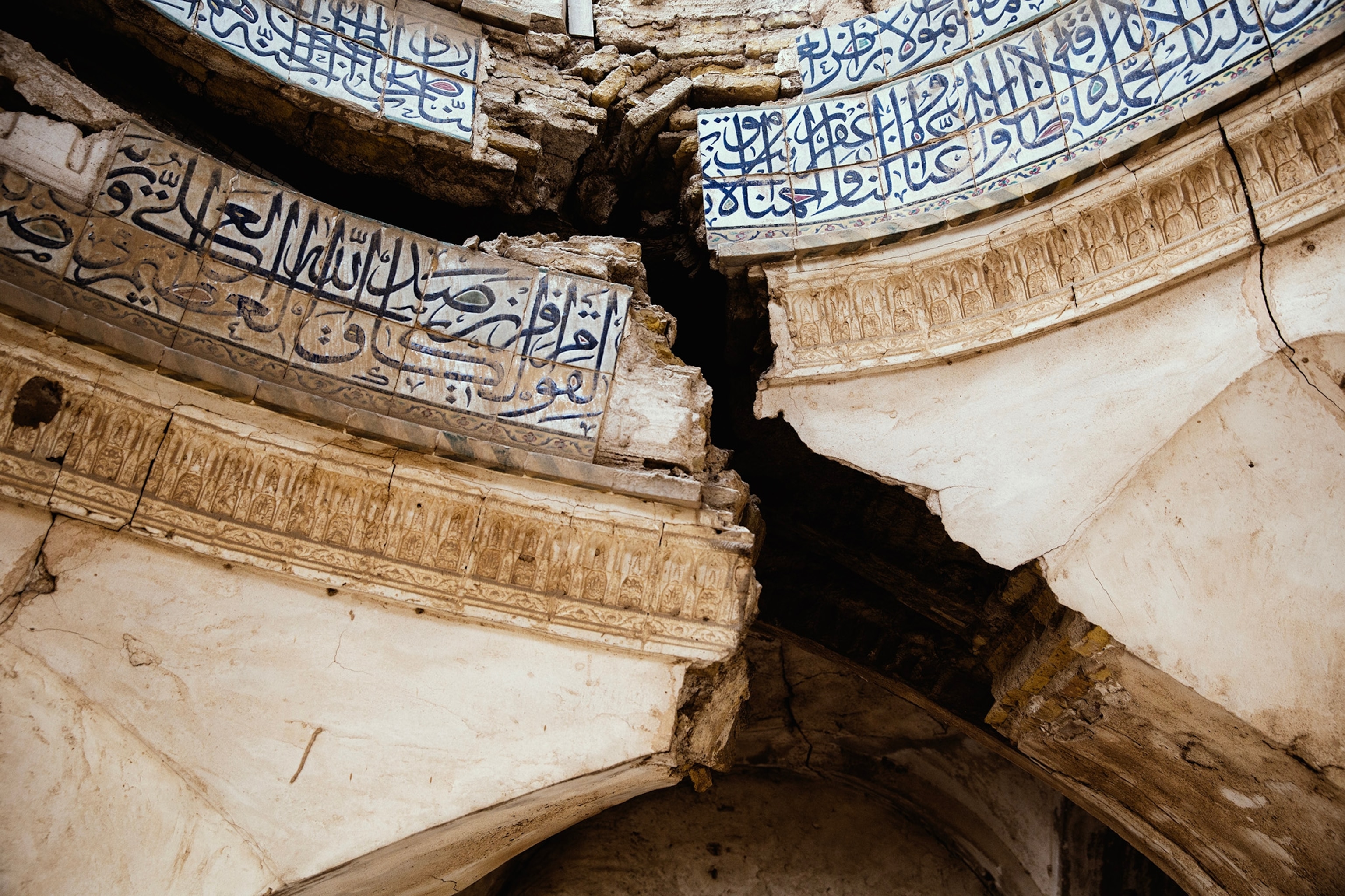 A large crack forms along the roof of a building