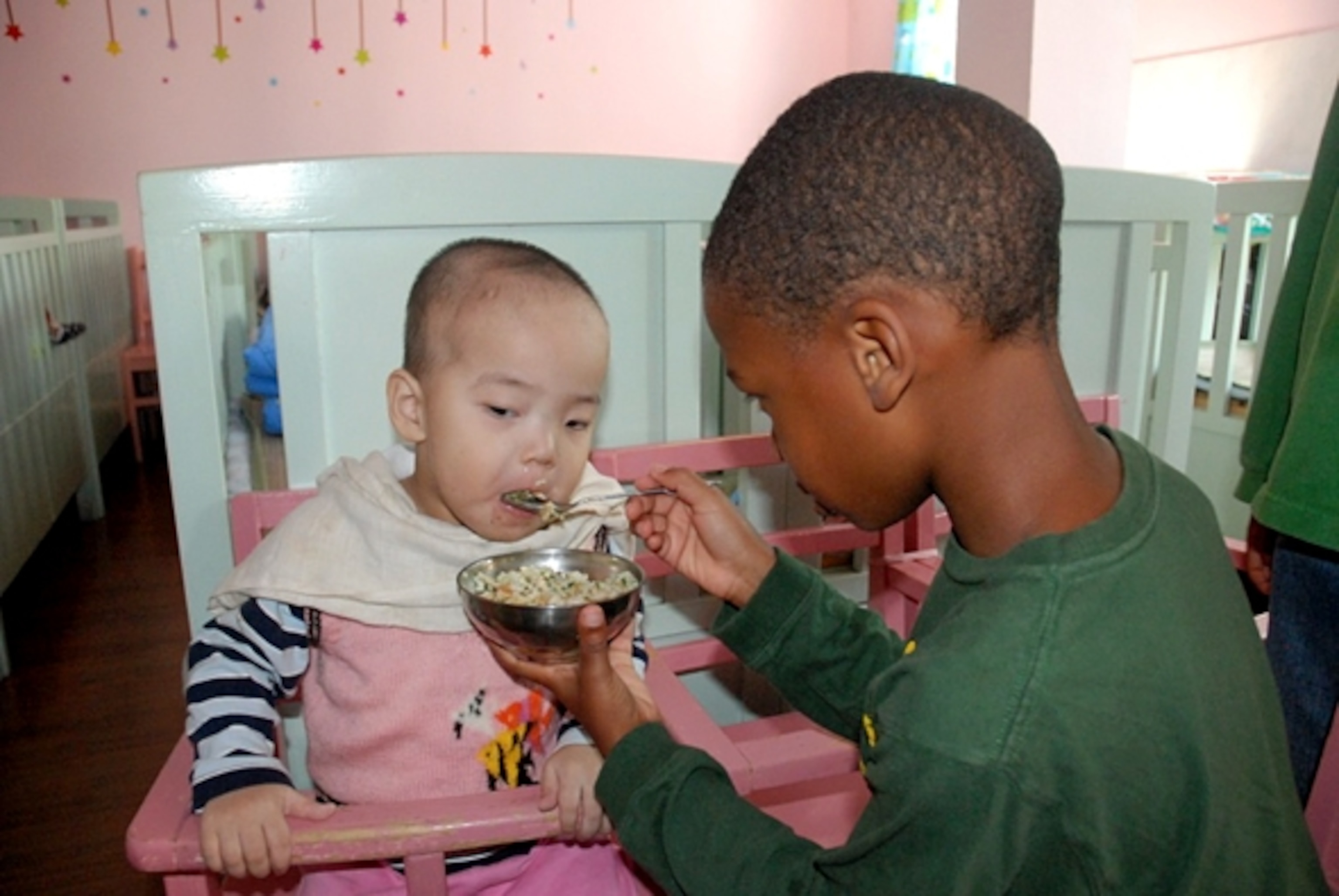 Cameron feeding an infant at an orphanage in Shanghai. (Photograph by Heather Greenwood Davis)
