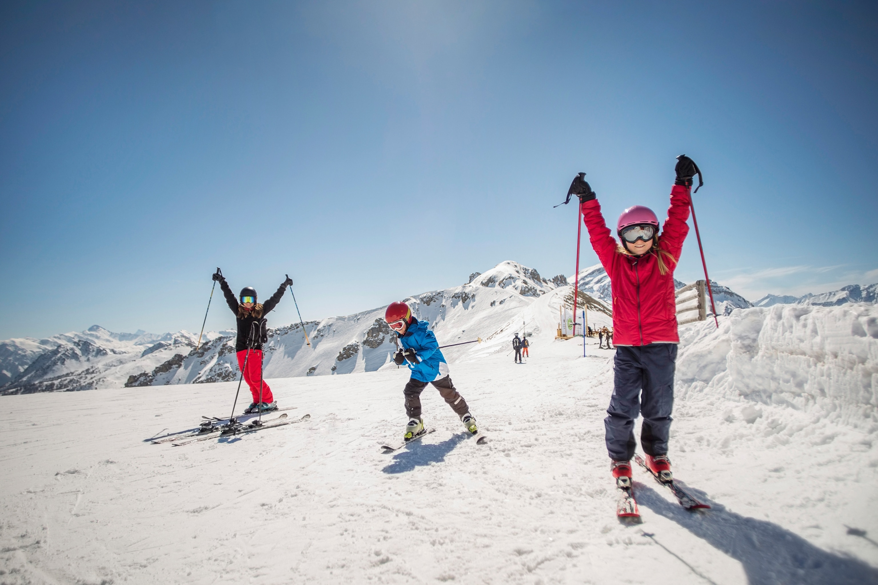 A group of three kids at the top of a slope.