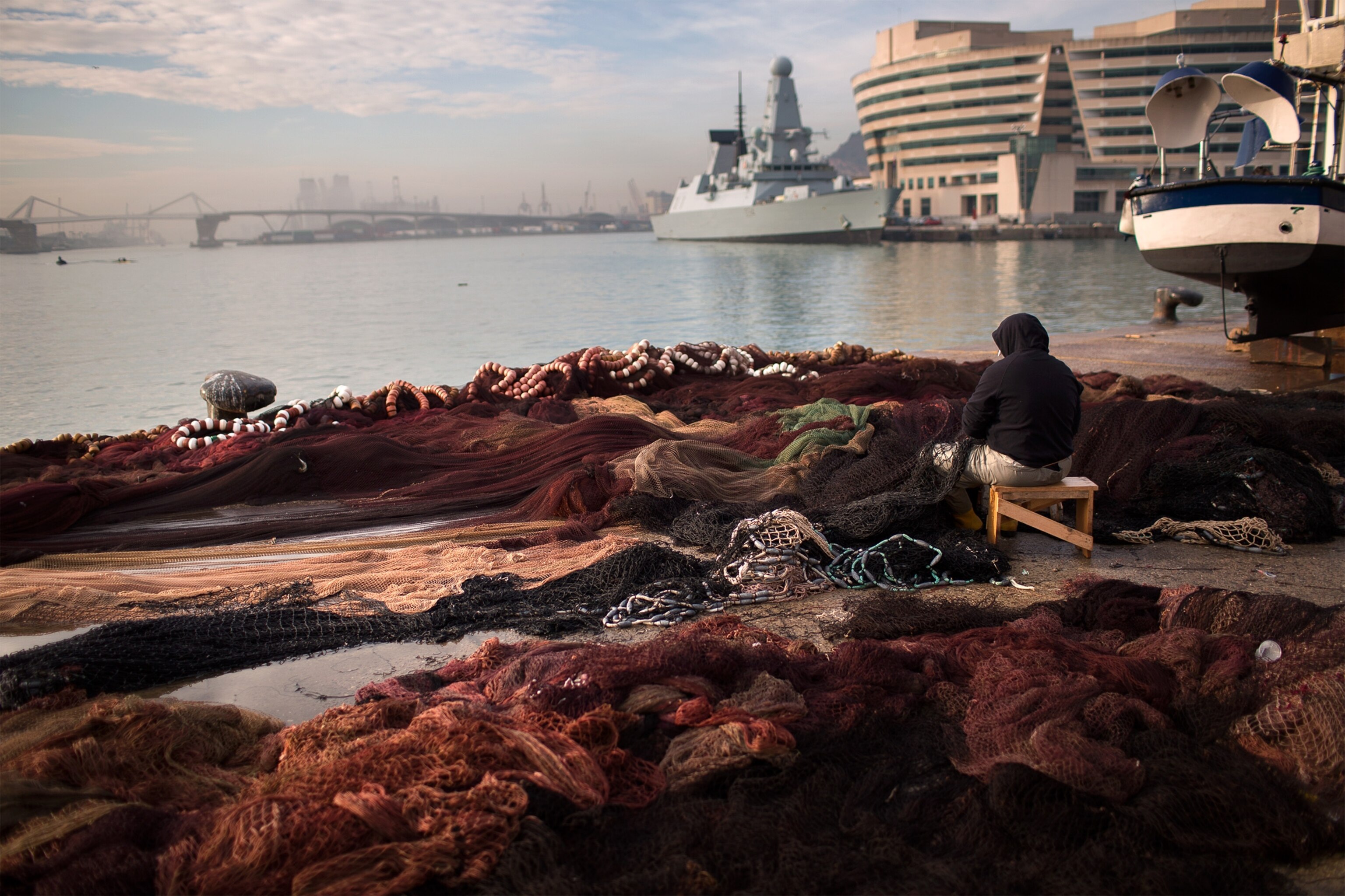 Fisher picture - a man fixes his nets at the port of Barcelona, Spain
