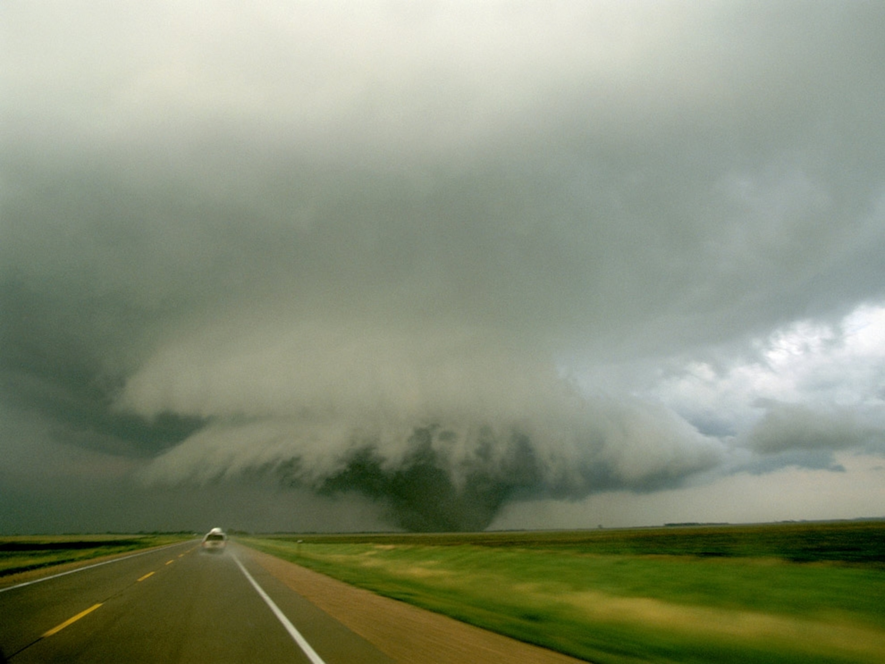 A tornado with a storm chasing van following it