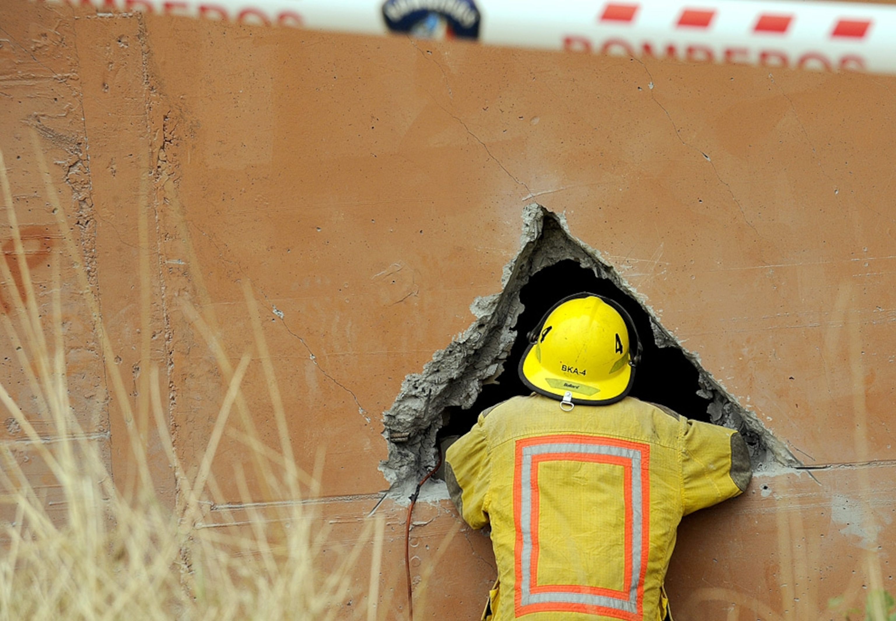 a rescue worker looking into a building destroyed by the Chile earthquake
