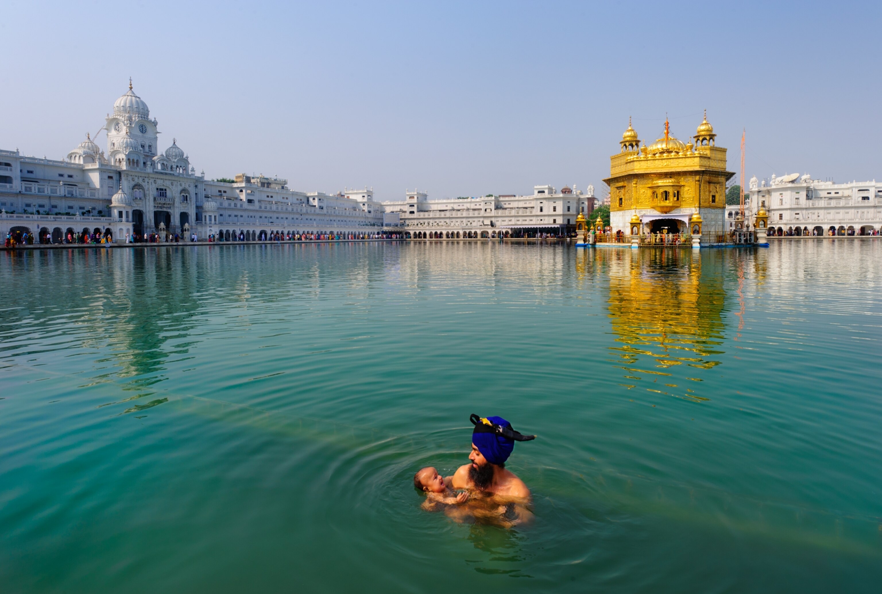 a father and child in the Holy Pool of Nectar at the Golden Temple, India