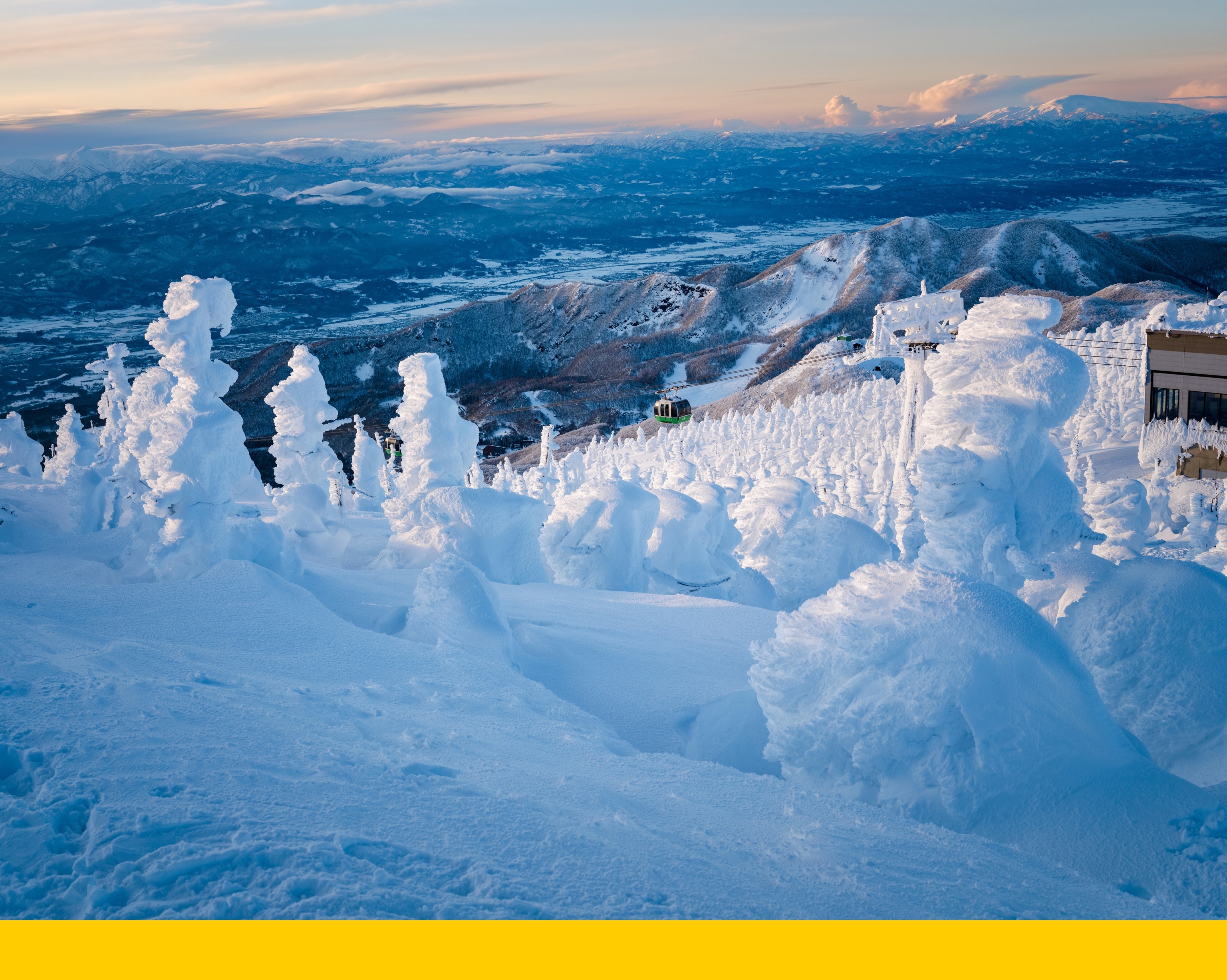 A photograph of the 'Zao Snow Monsters' of Japan, which are a phenomenon created at the top of Mount Zao where Maries' fir trees get pelted with moisture from icy winds and get so encased that they begin to lean over, giving them the look of storybook monsters.