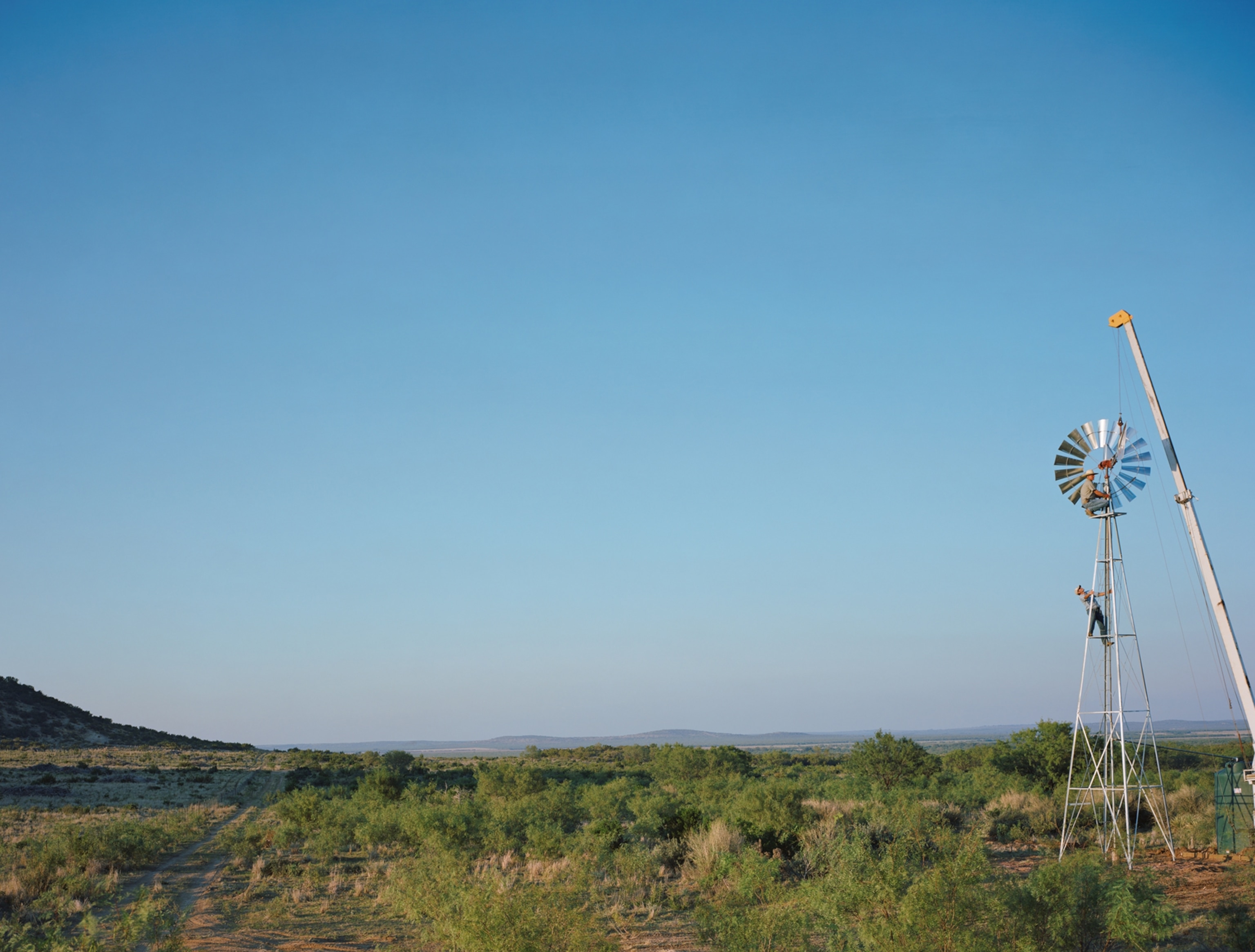 men installing the head of a windmill