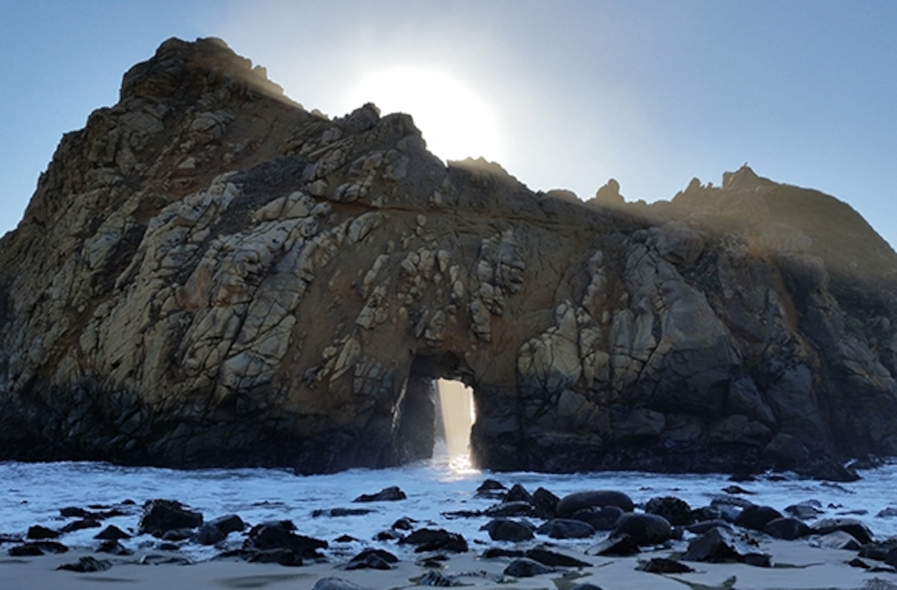 Sunlight streams through Keyhole Arch at Pfeiffer State Beach . (Photograph by Robert Reid)