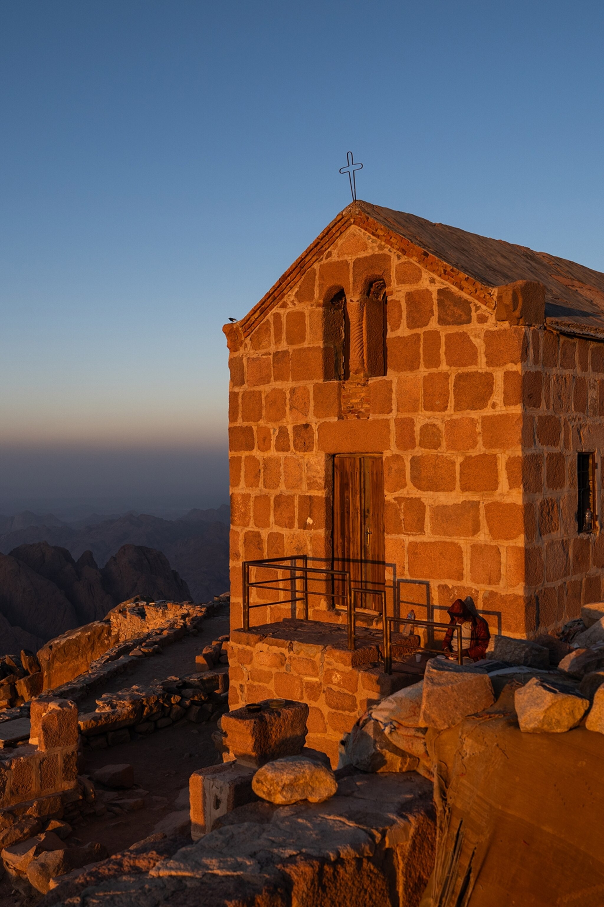 A chapel on the top of a mountain at sunrise.