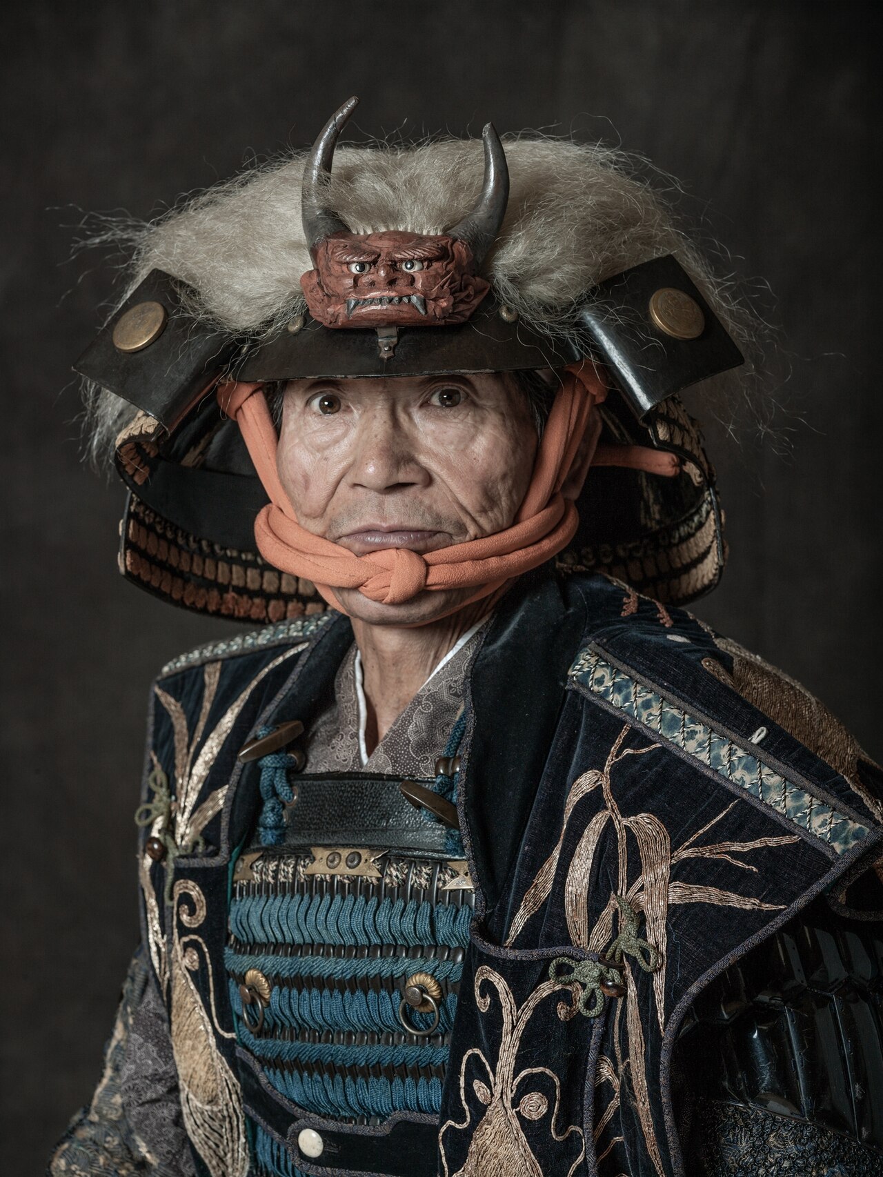 Picture of older man dressed as taisho in hat with horns.