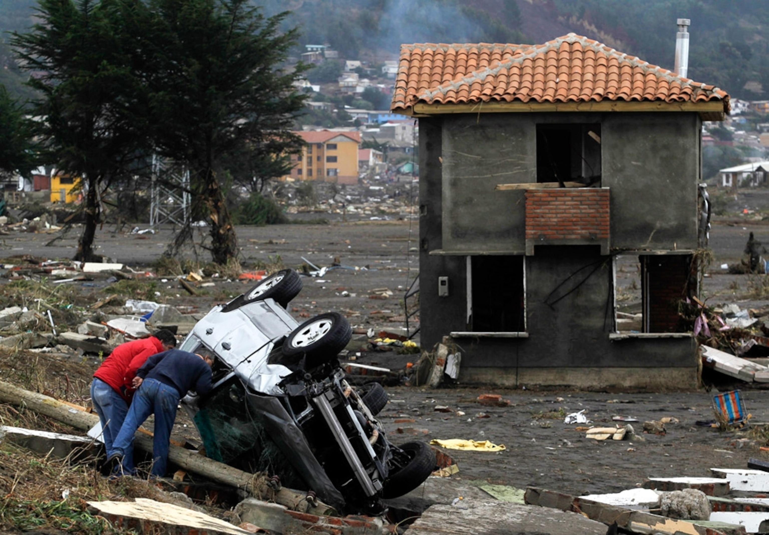 people peering into a vehicle after Chile tsunamis
