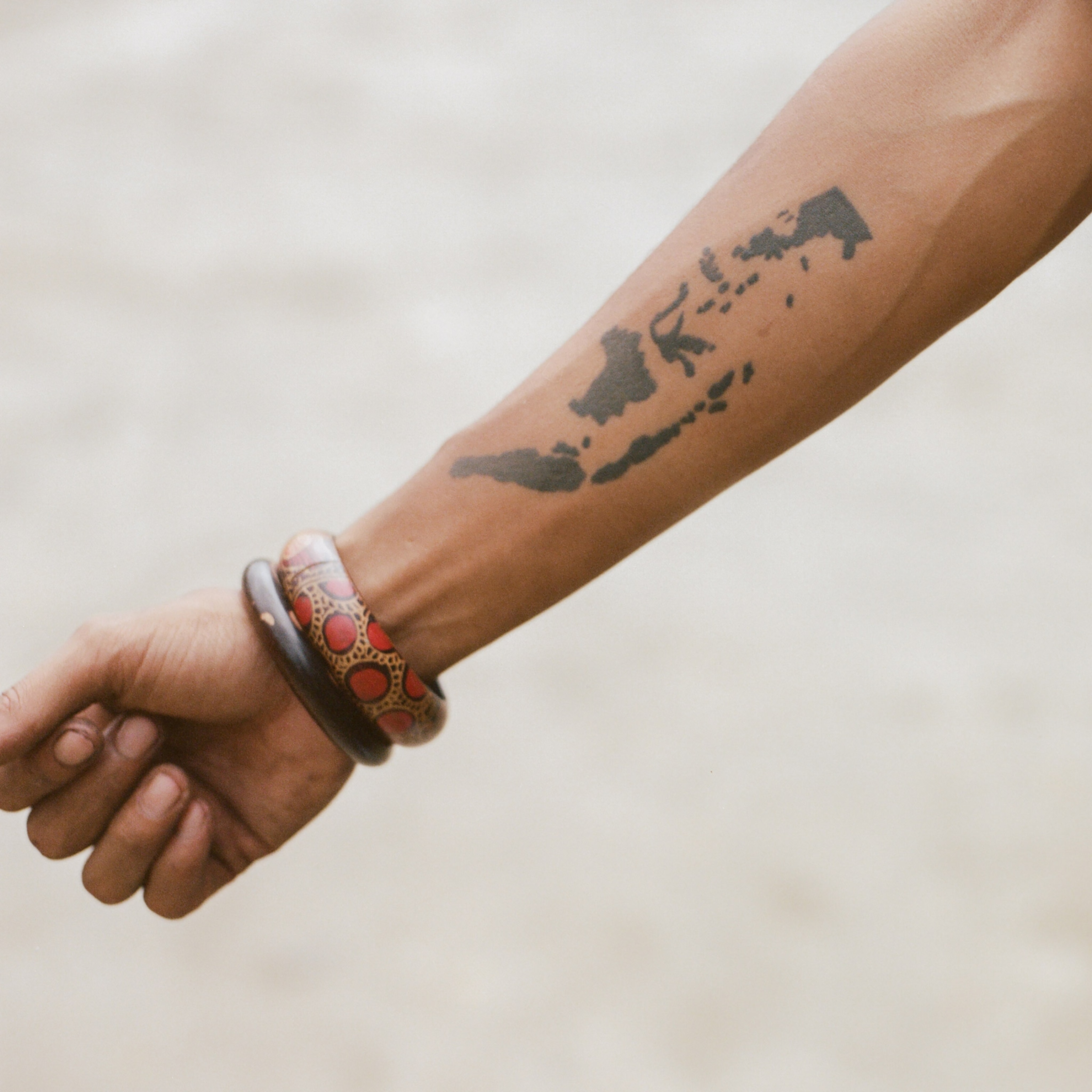 a tattoo of a map of Indonesia on a scooter enthusiast's arm