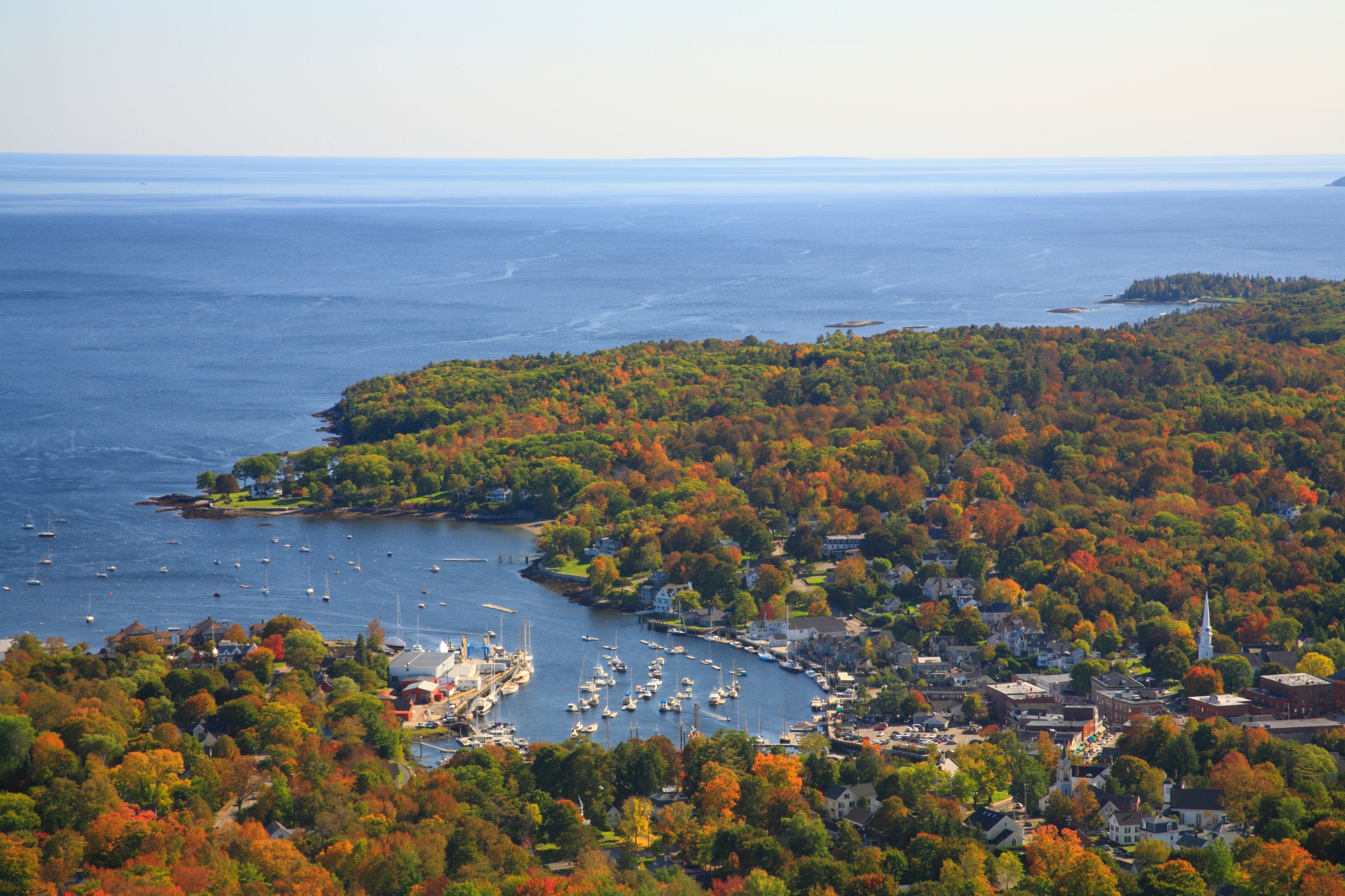 An aerial view of a town by the water in Autumn.
