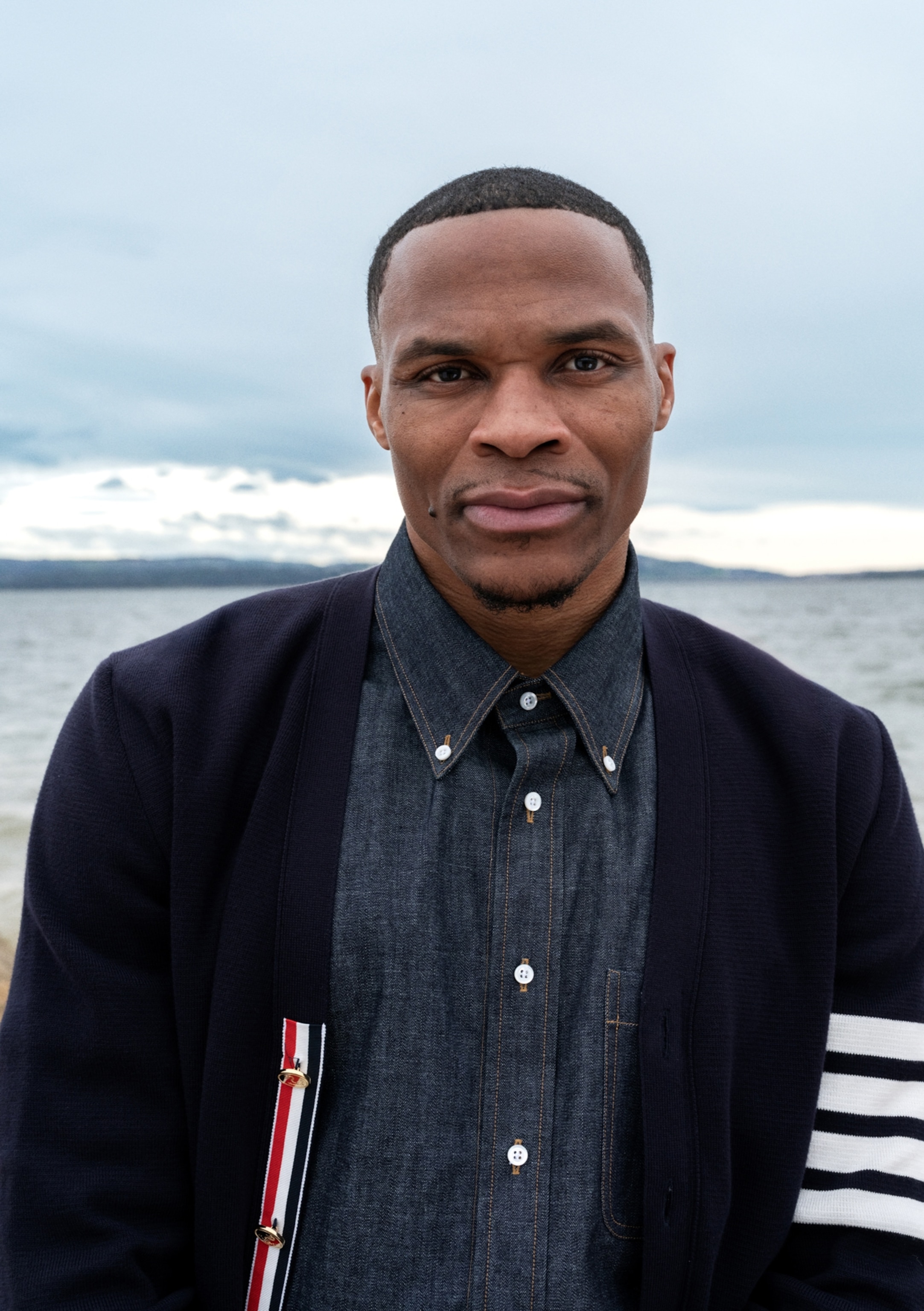 A man stands for a portrait in front of the ocean