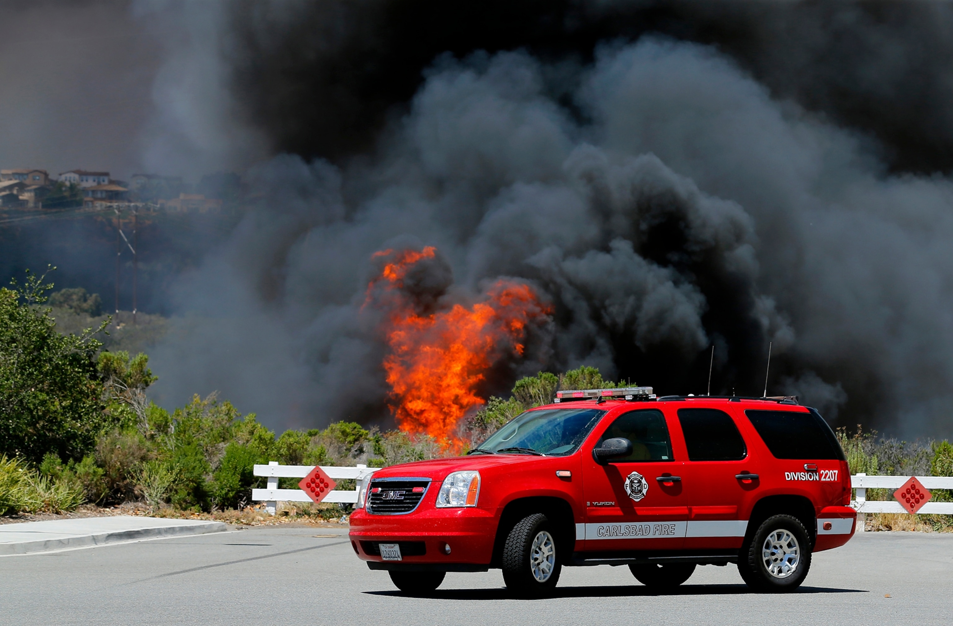 Wildfire climbs a canyon toward homes Wednesday, May 14, 2014, in Carlsbad, Calif.