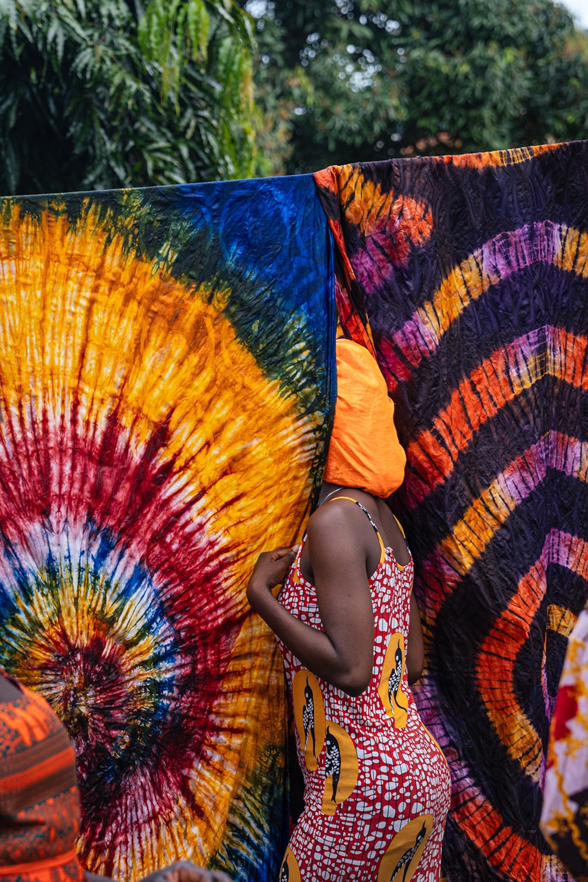 a lady between colourful sheets of fabric