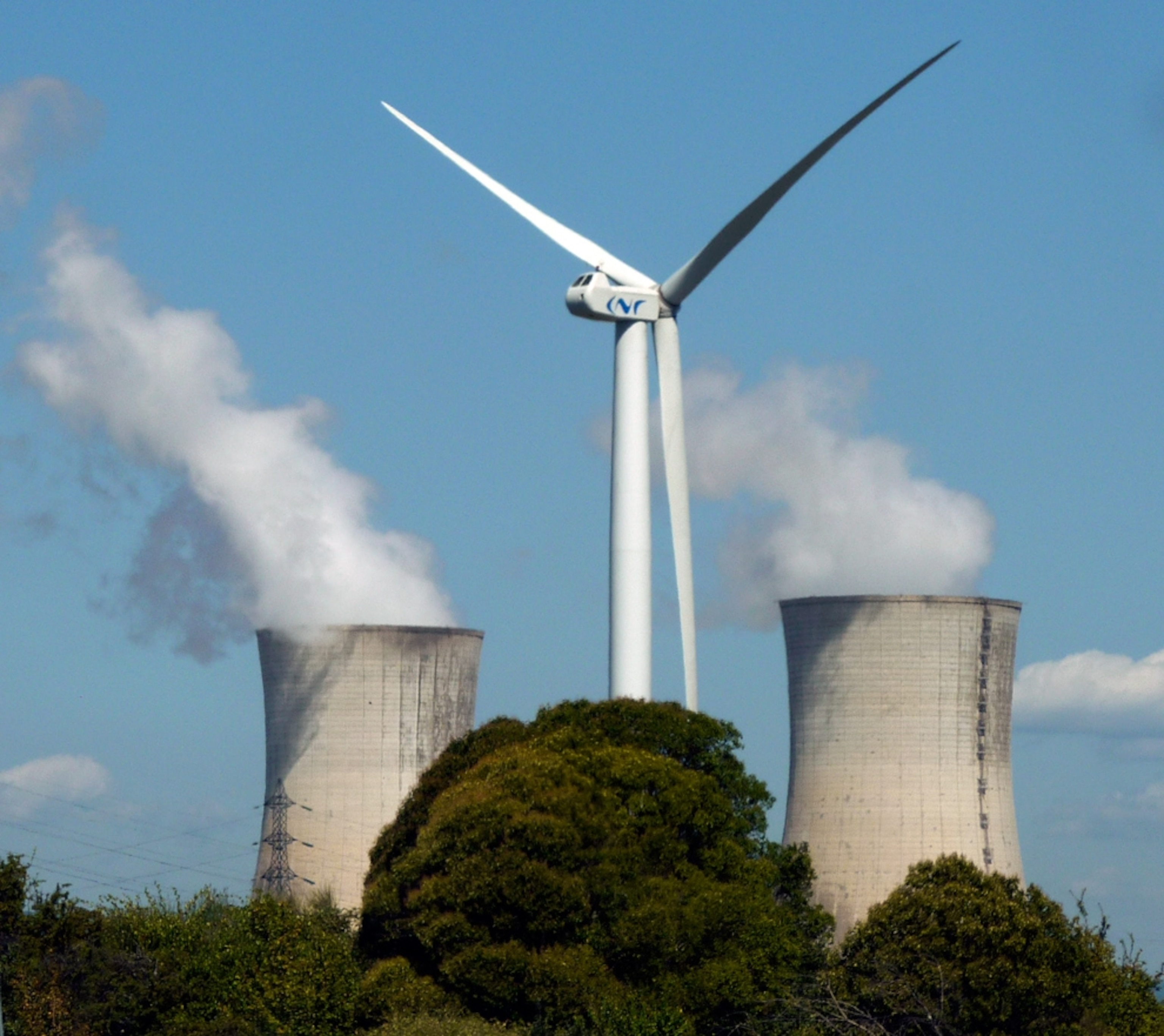 A wind turbine near the cooling towers of the Cruas nuclear plant in France