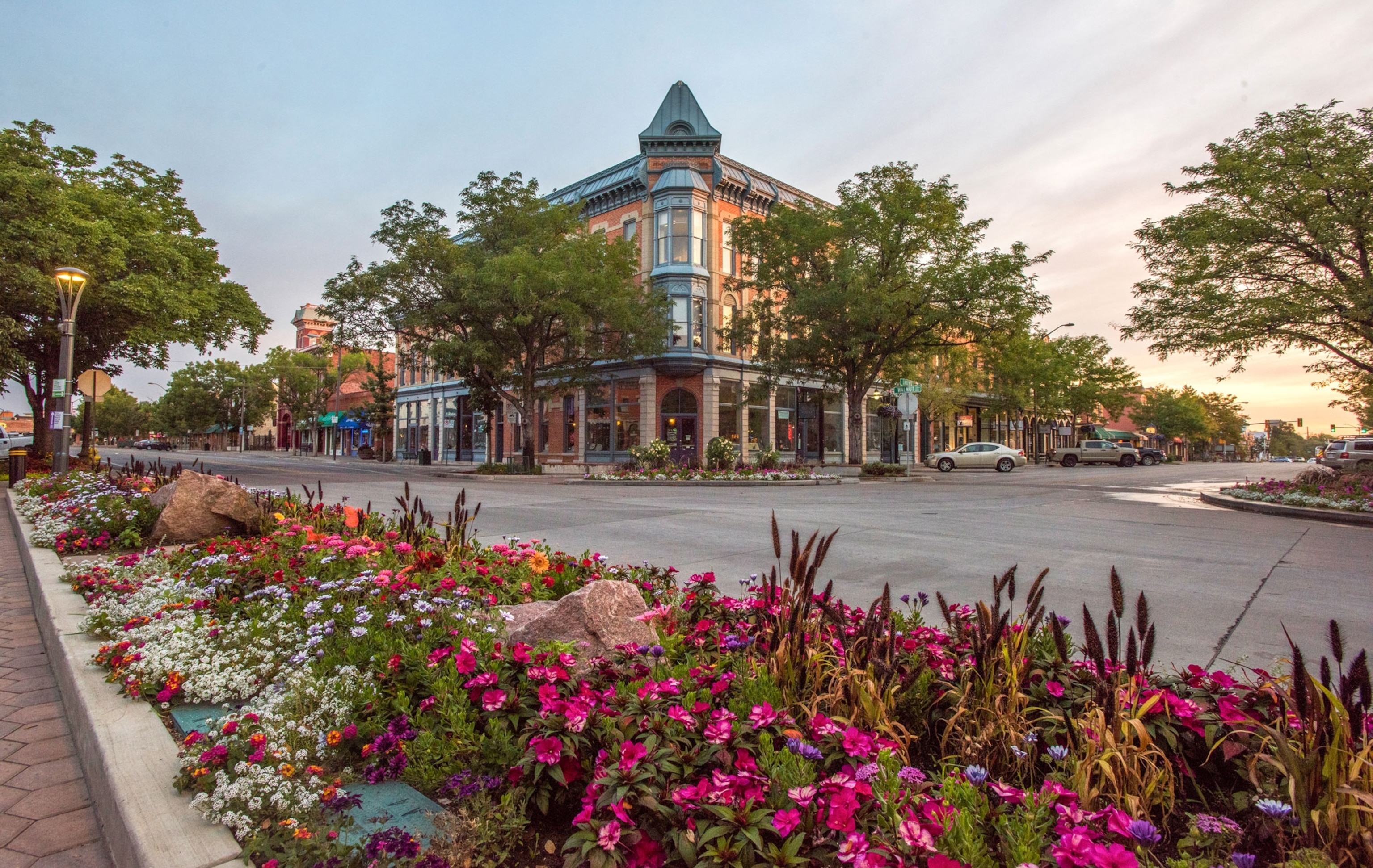In the near distance is an old hotel with a paved road and flower garden in the foreground.
