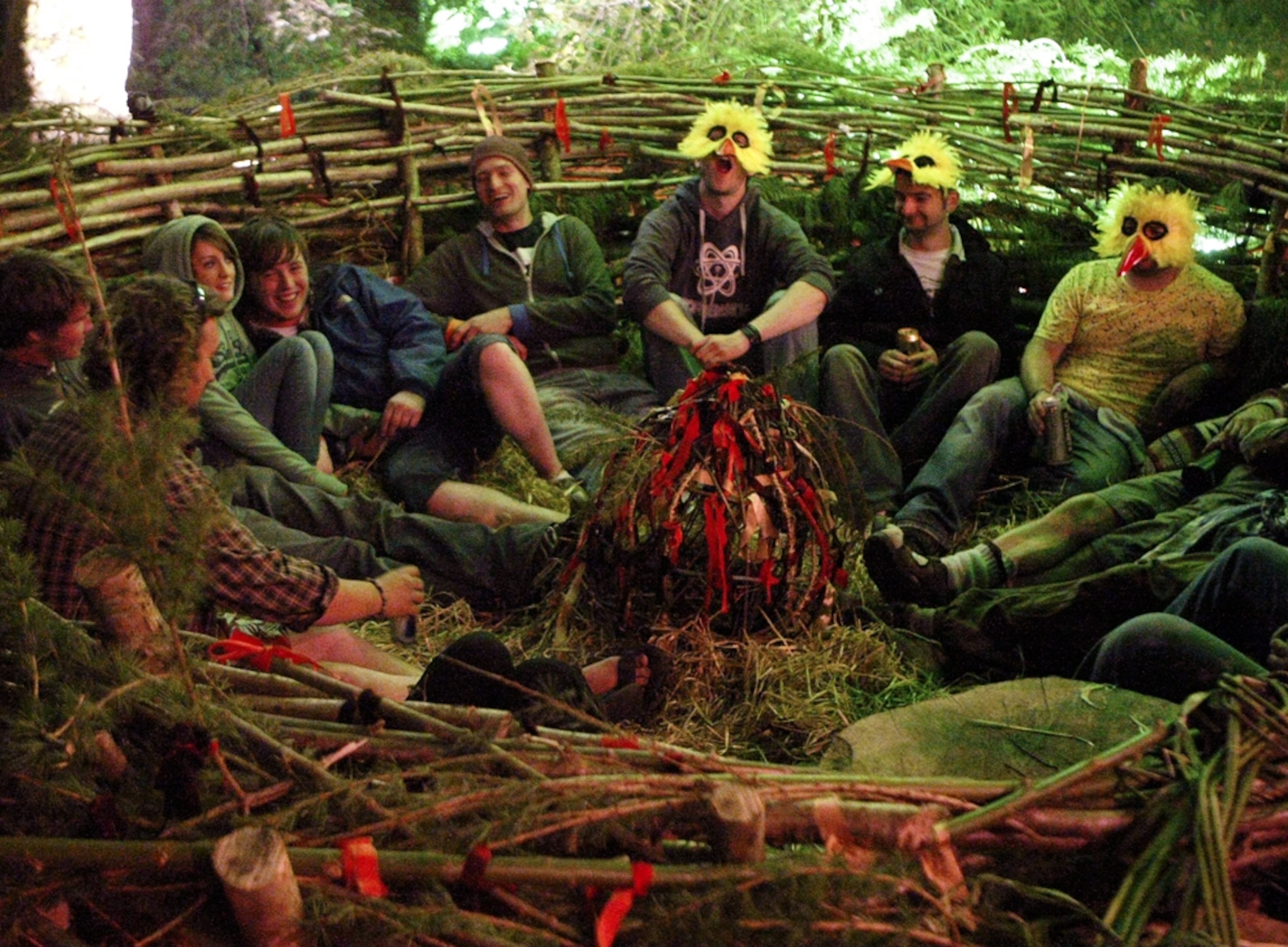 On the eve of the first day of summer, revelers, some wearing chicken masks, sit in a friendship nest.