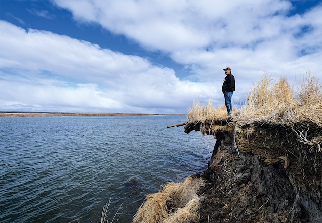 Tribal elder Warren Jones stands where erosion is eating away at Yup’ik lands in southwest Alaska. Permafrost and sea ice once formed a protective barrier, but warming temperatures have wreaked havoc on local waterways.