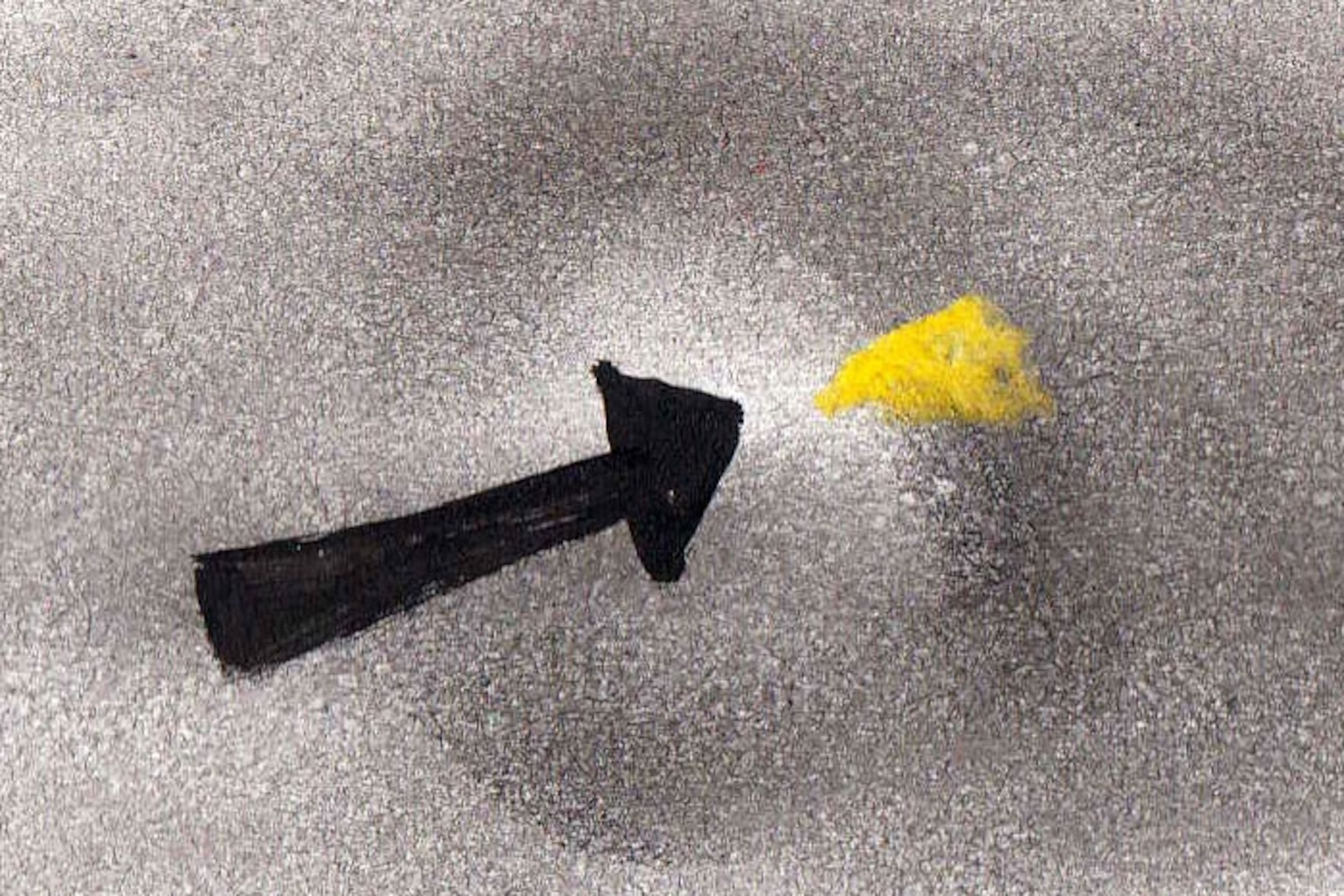 Drawing of an arrow pointing to a little yellow speck in a large black blot