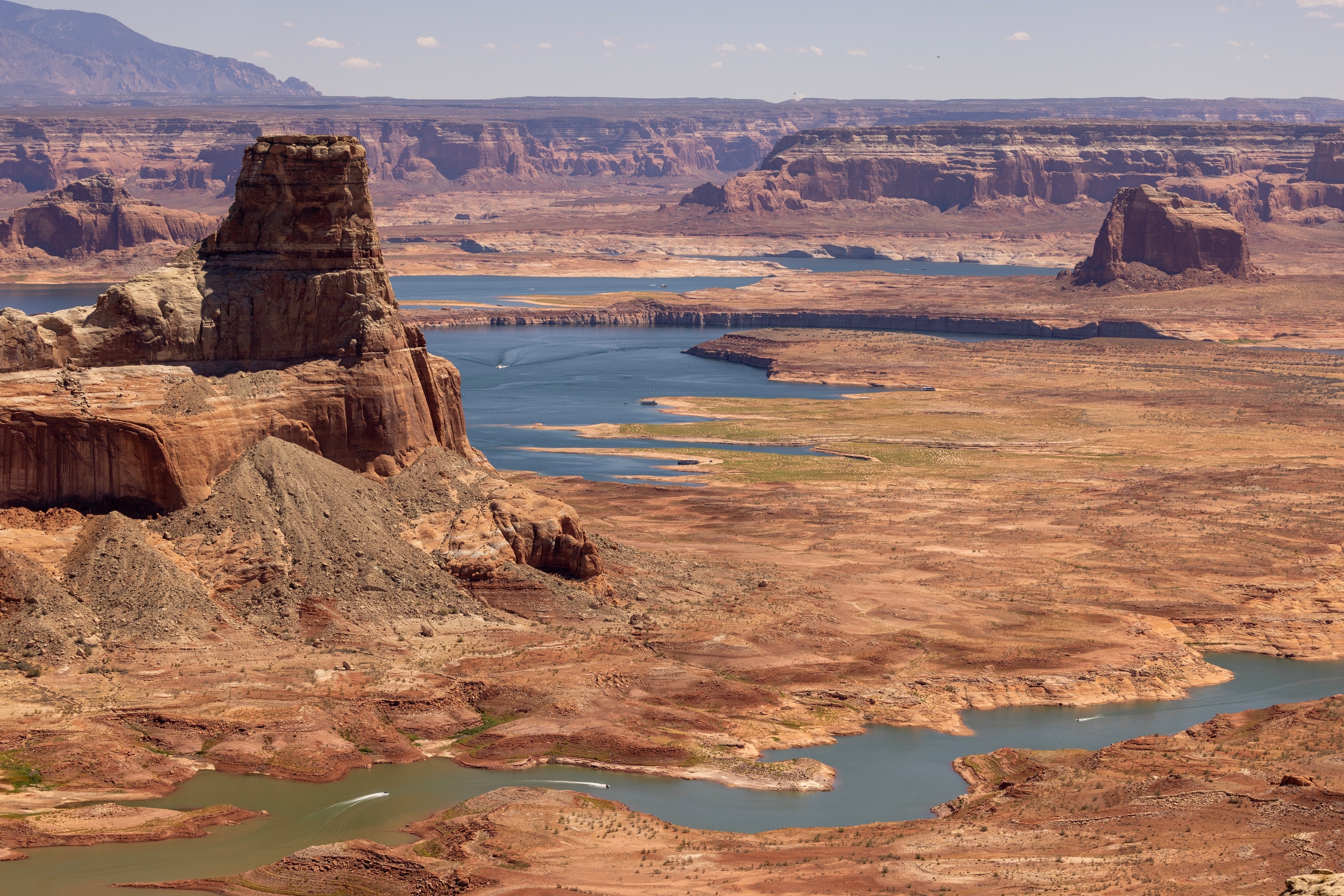 A wide shot of reddish-brown rock formations cut through with blue waterways