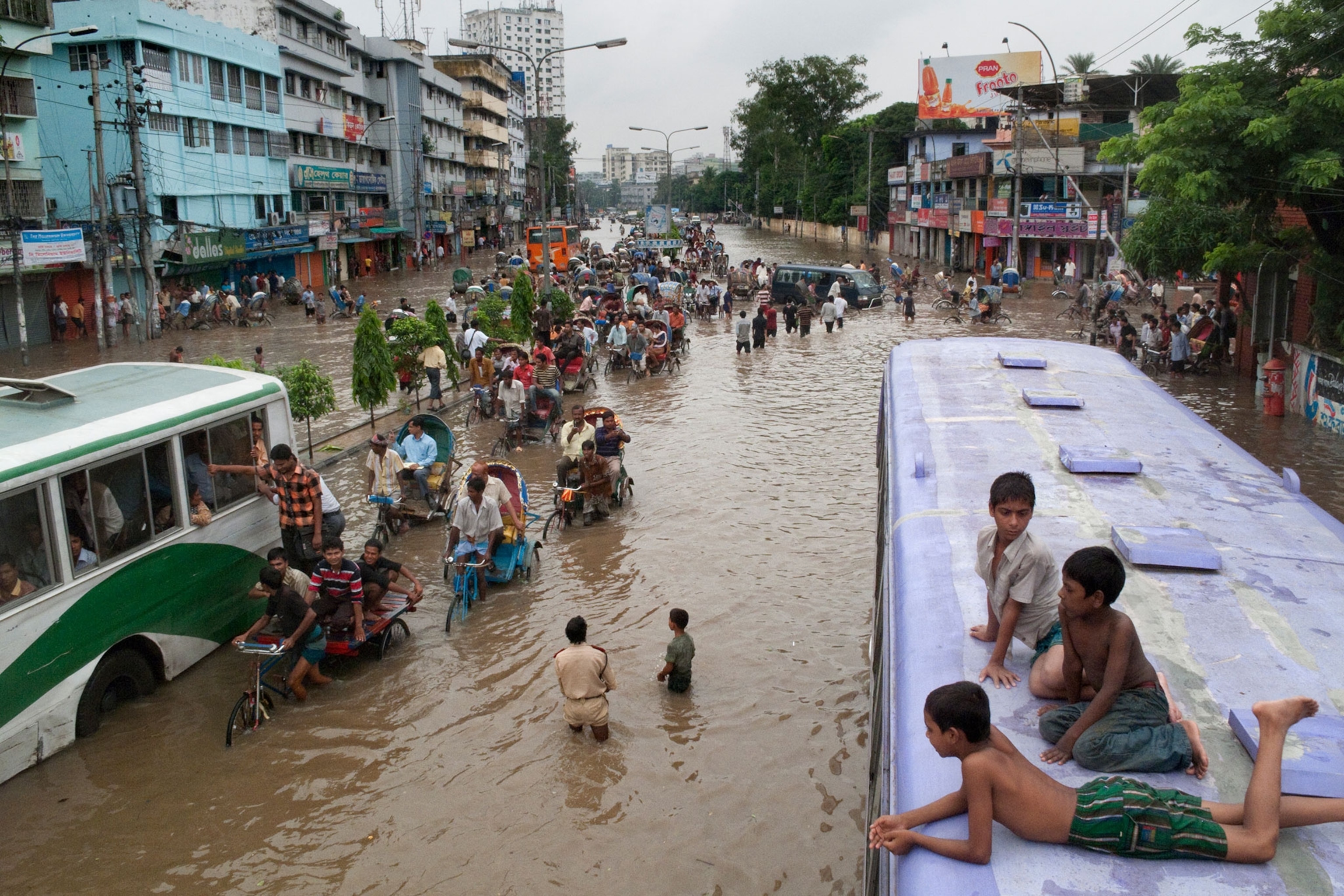 Bangladeshis slog through Dhaka after a downpour turns street to river