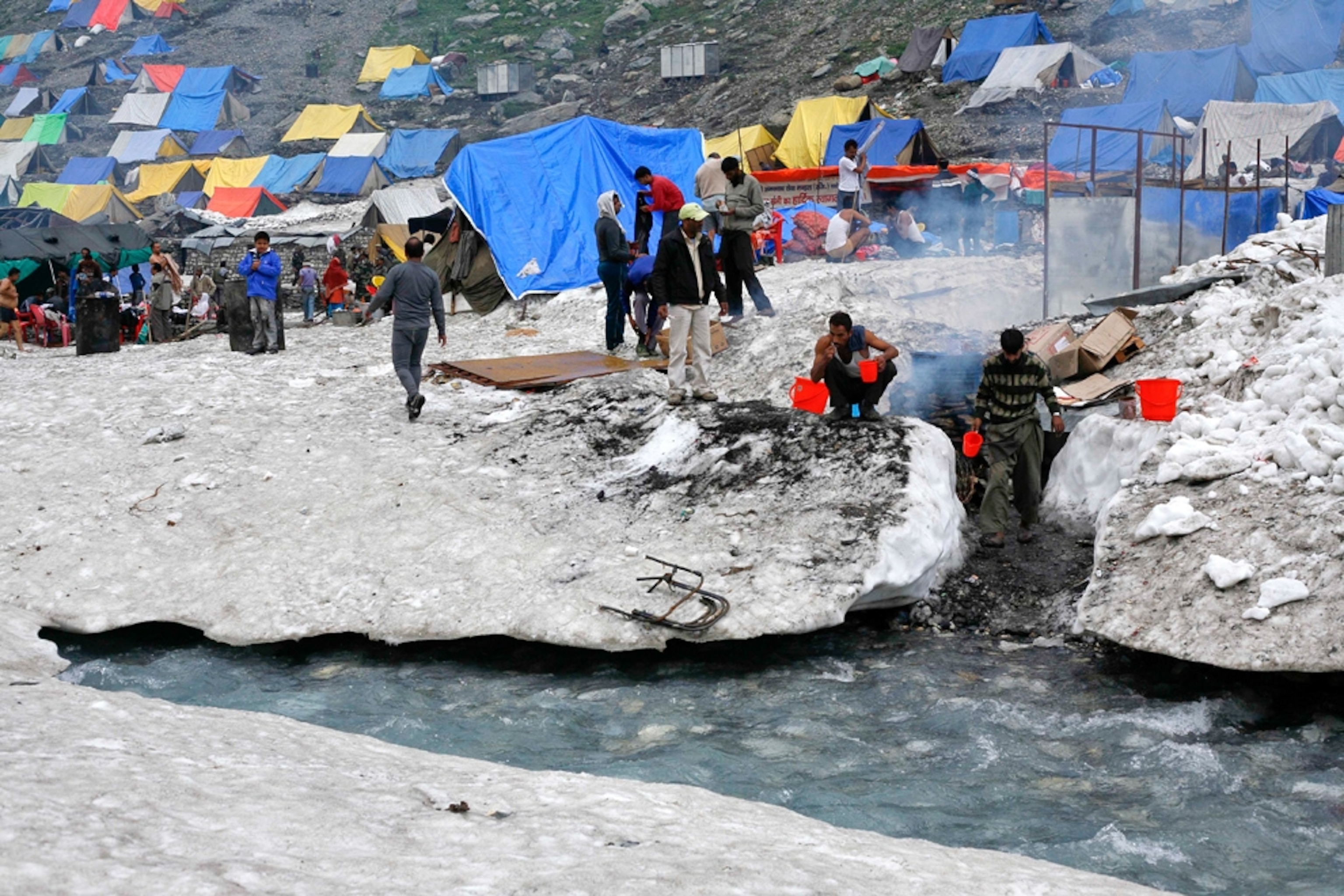 Kashmiri Muslim camp owners boil water on a traditional stove for the bathing purpose for Hindu pilgrims near the Amarnath cave.