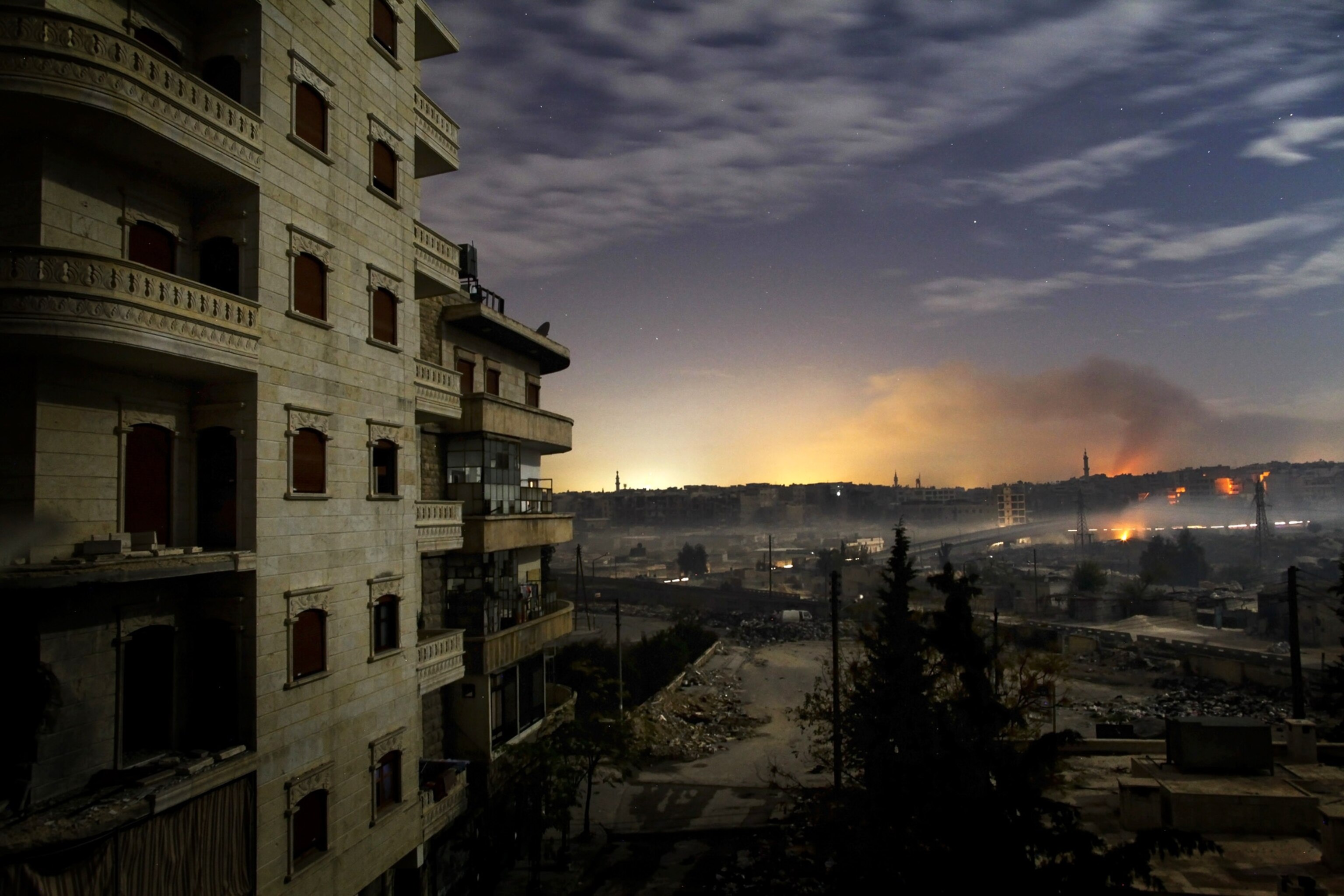 Aleppo picture - smoke and light mix in an image taken during fighting in the Syrian city of Aleppo