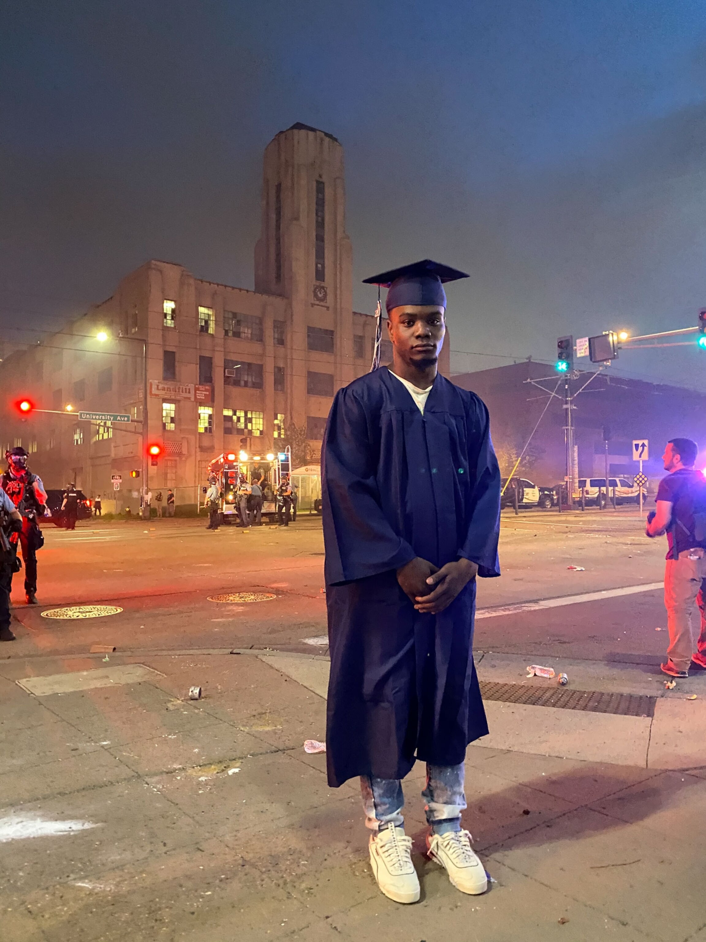 a recent high school graduate standing near a protest in Minneapolis