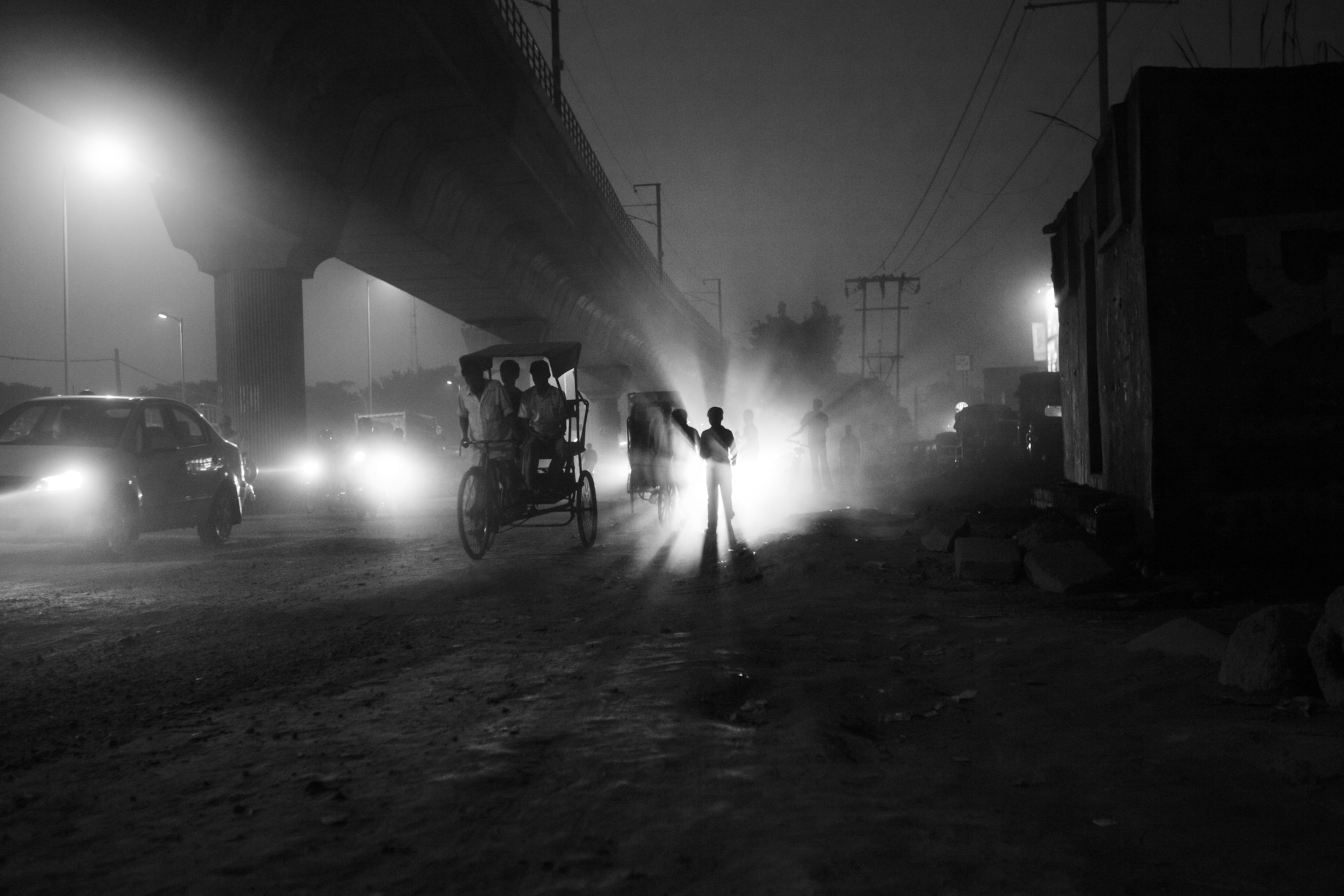 A boy stands amidst the evening rush on a main road. The close-by Azadpur Mandi, one of India's largest vegetable and fruit wholesale markets, attracts thousands of people every day, making it an ideal ground for both legal and illegal trafficking. The area is well-known for drug abuse and drug marketing.