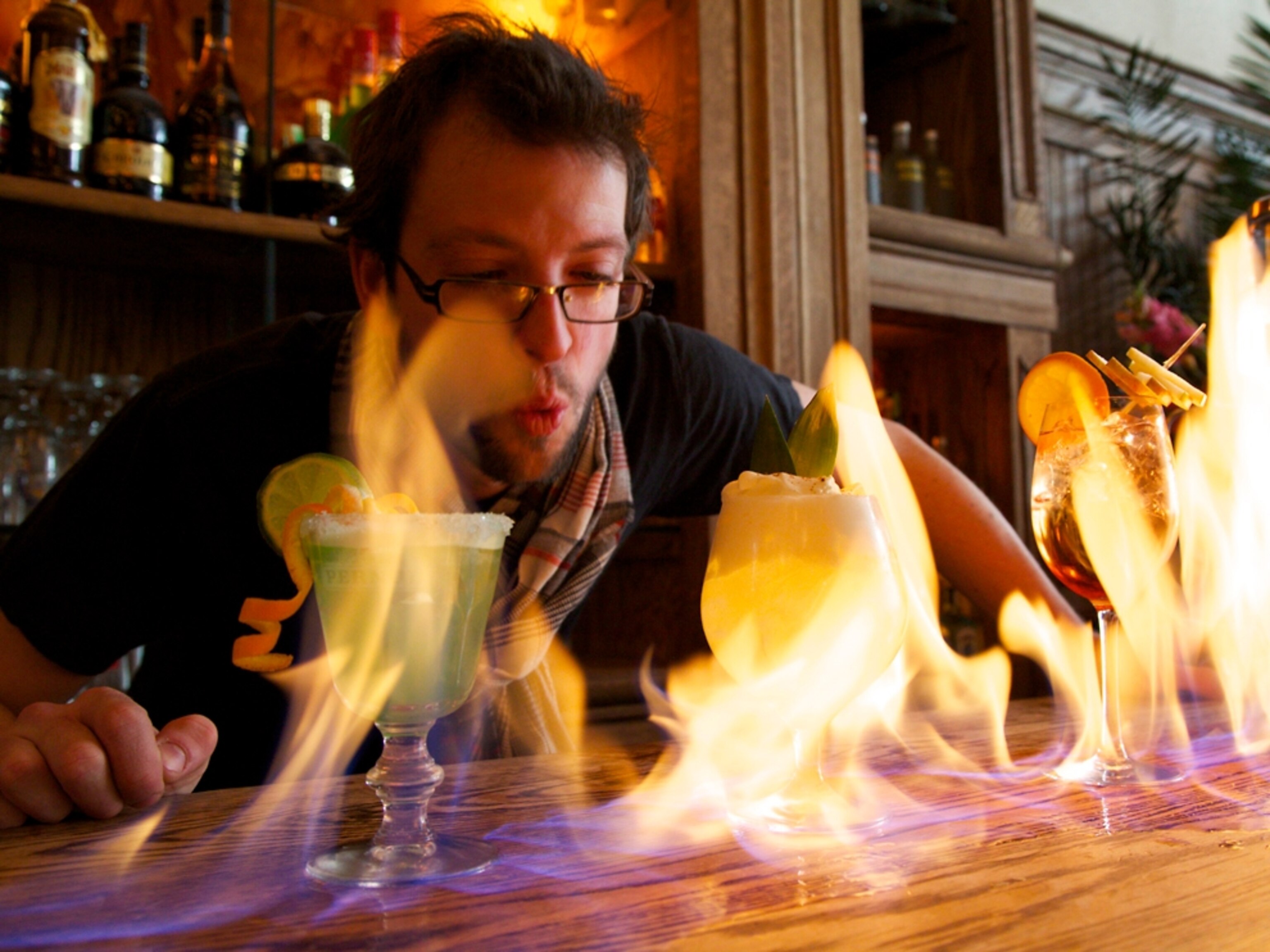 A bartender lights up cocktails.